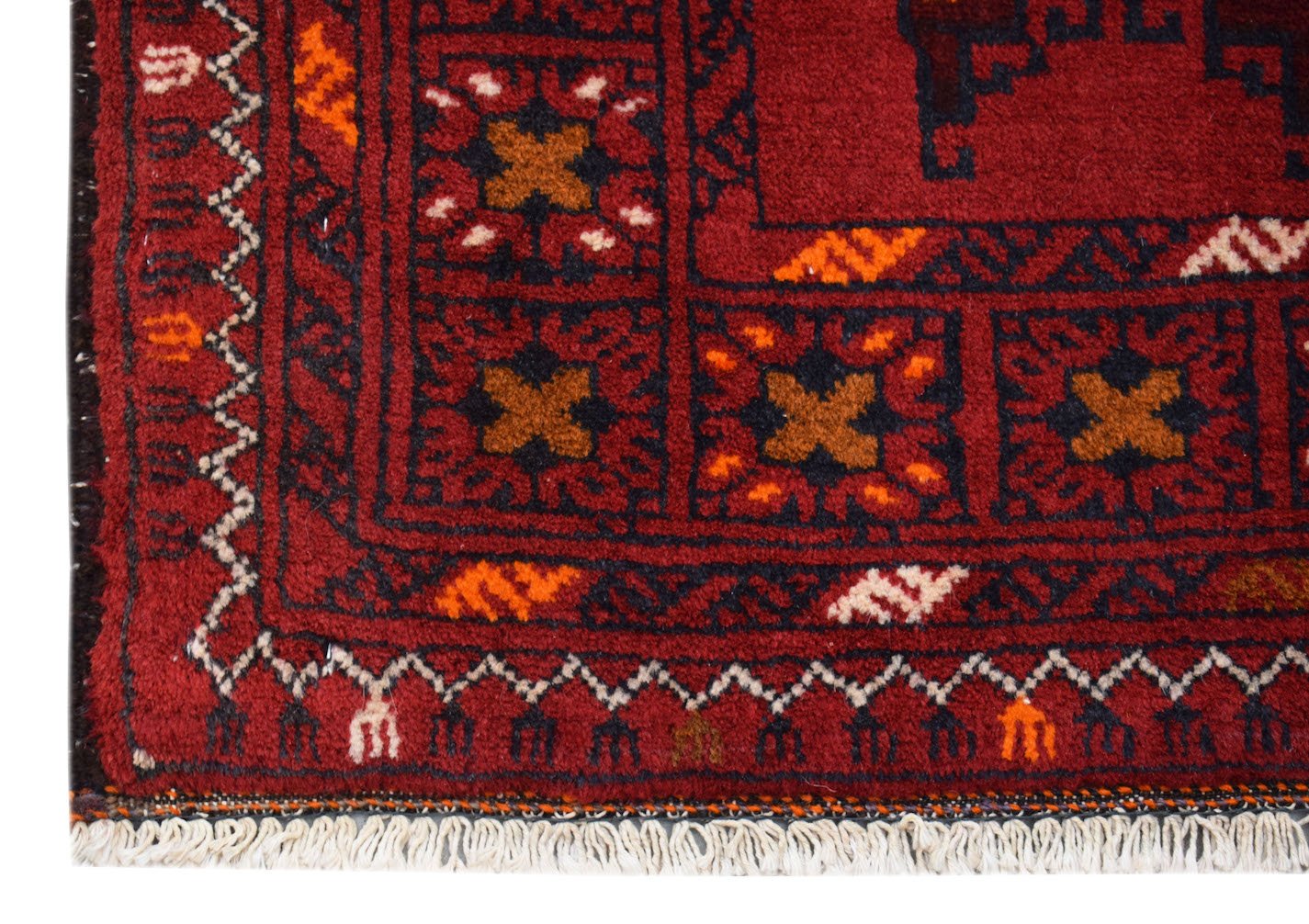 A handmade vintage Afghan Baluch rug featuring geometric patterns in deep red, brown, and blue.