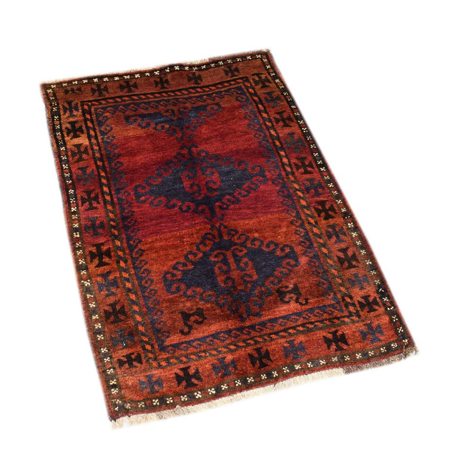A handmade vintage Afghan Baluch rug featuring dark red, blue, and brown tribal geometric patterns.