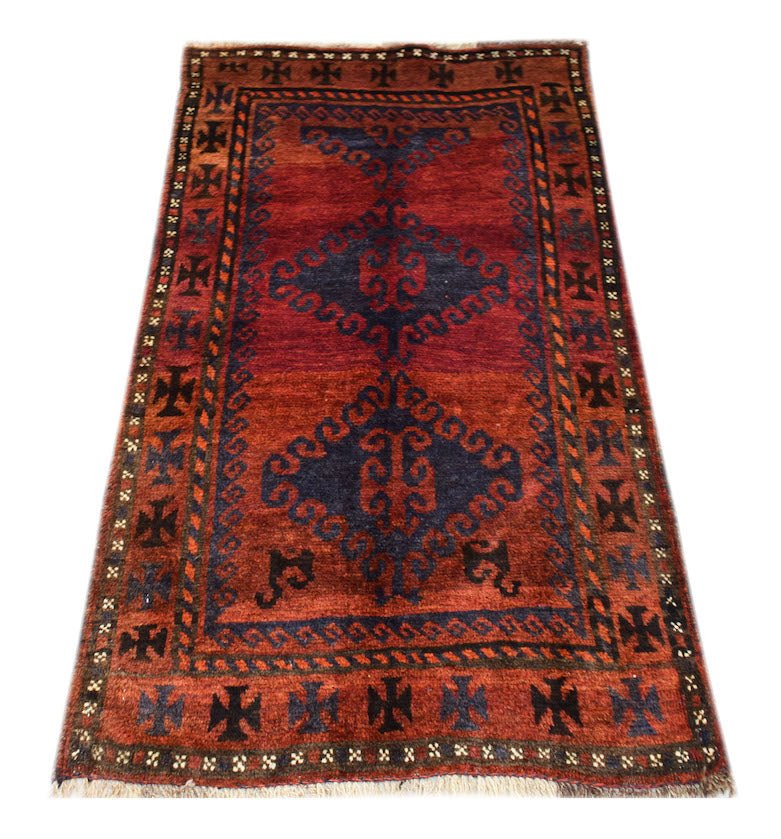 A handmade vintage Afghan Baluch rug featuring dark red and blue geometric tribal patterns.