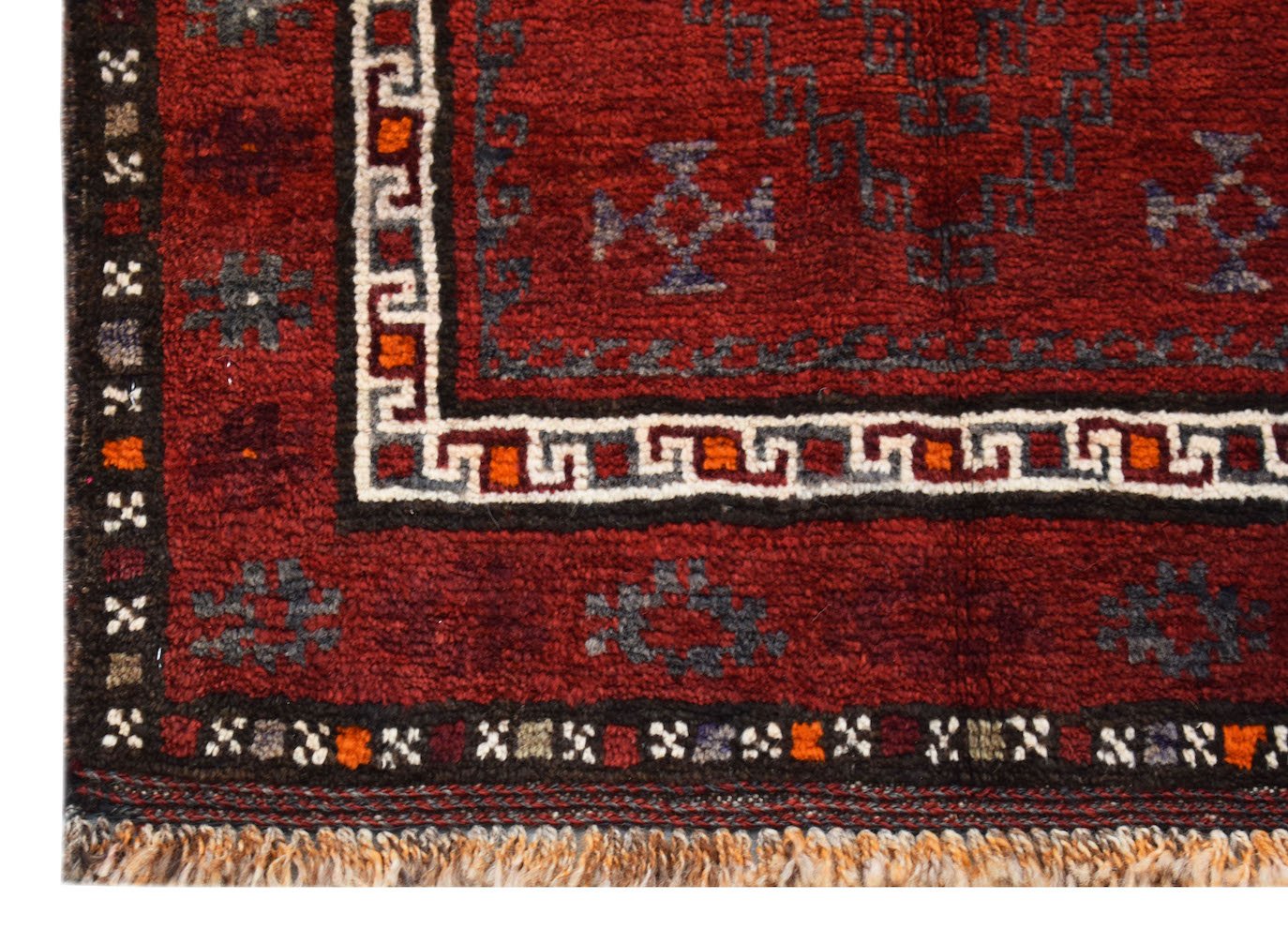 A vintage handmade Afghan Baluch wool rug featuring a deep red field with geometric tribal motifs.