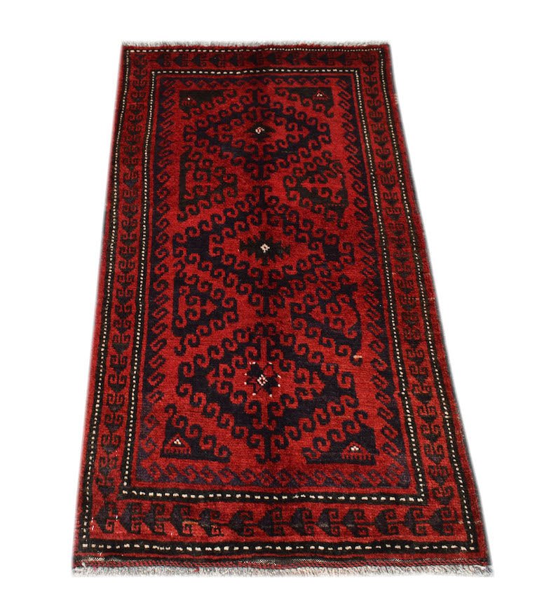 A vintage handmade Afghan Baluch rug featuring a geometric pattern in deep red and black wool.