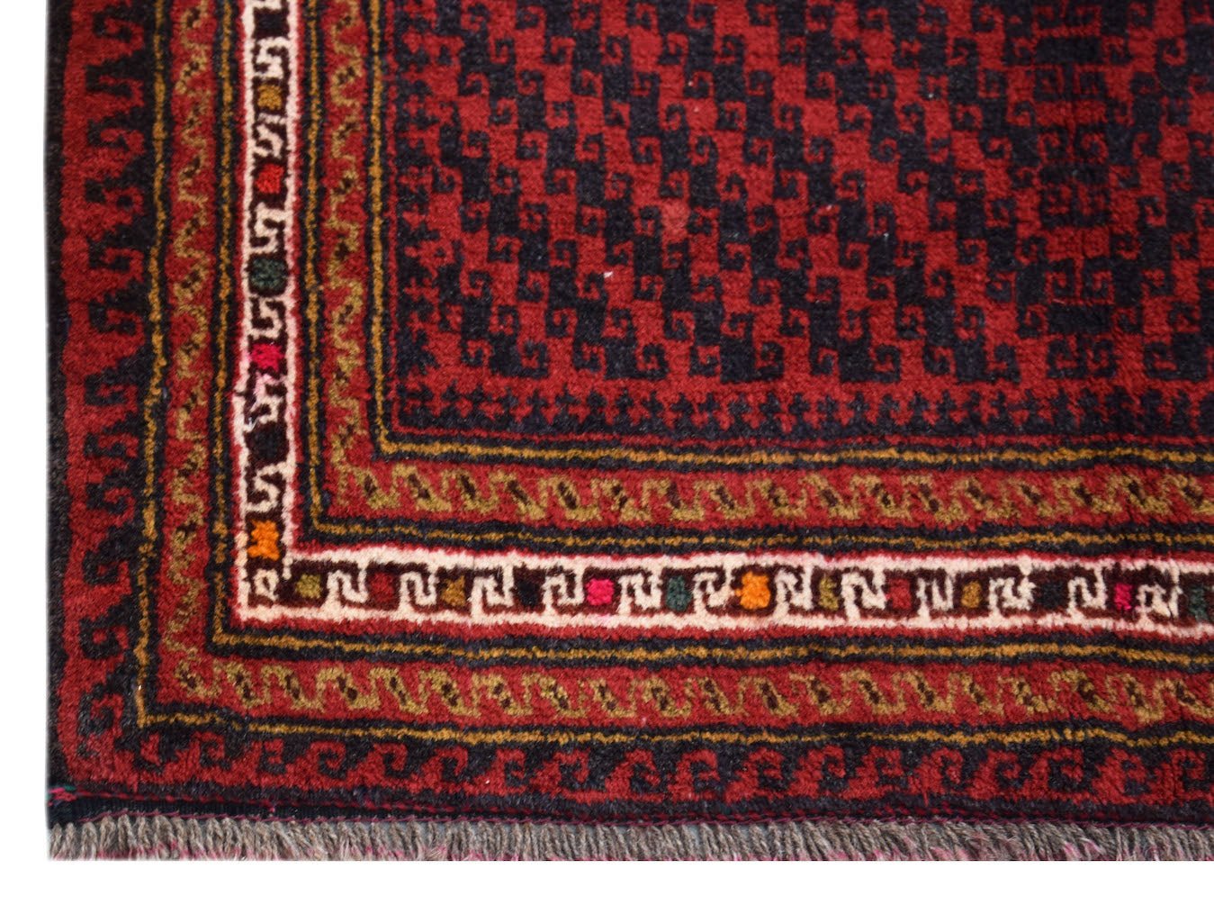 A handmade vintage Afghan Baluch rug featuring a geometric pattern in dark red, brown, and ivory.