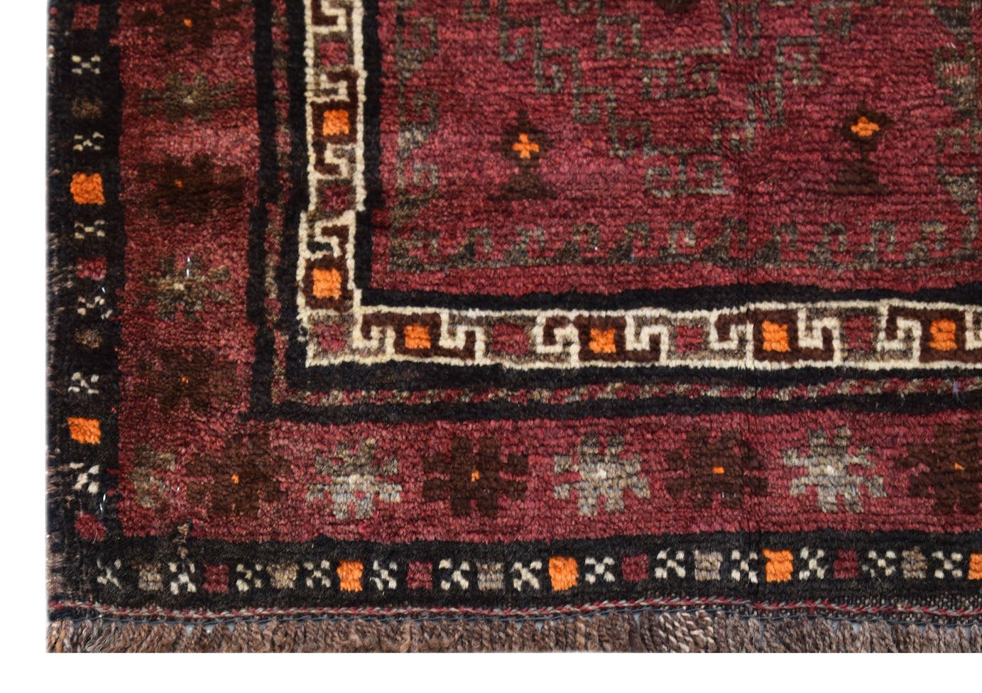 A vintage handmade Afghan Baluch rug featuring geometric patterns in deep red, brown, and ivory.