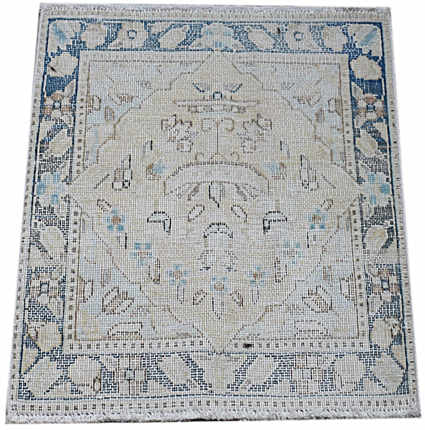 A mini vintage Persian Kerman rug featuring a central medallion and floral motifs in blue and beige.