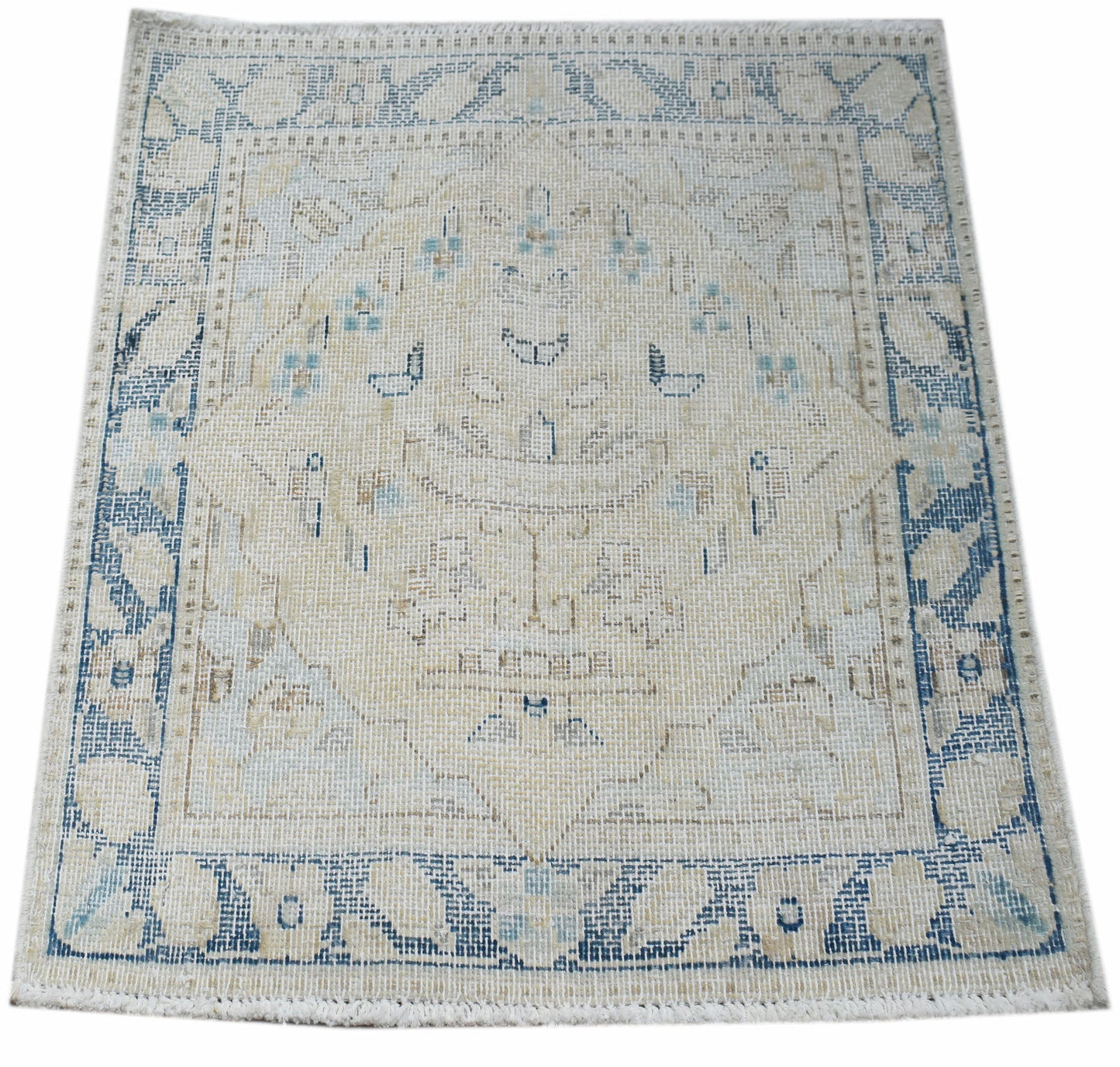 A mini vintage Persian Kerman rug featuring a central medallion in faded blue and beige tones.