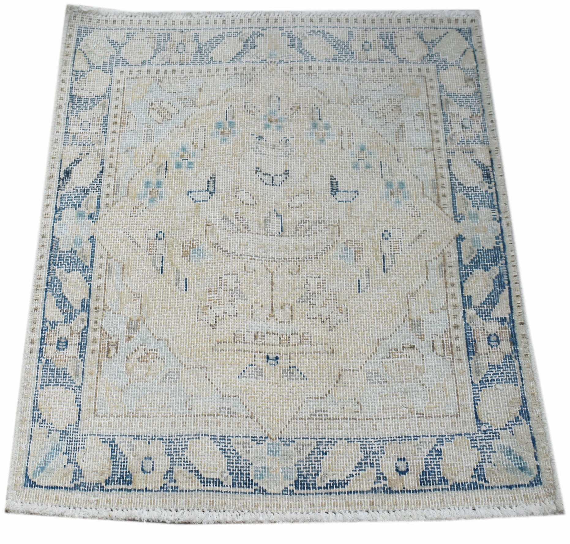 A mini vintage Persian Kerman rug featuring a central medallion in faded blue and beige tones.