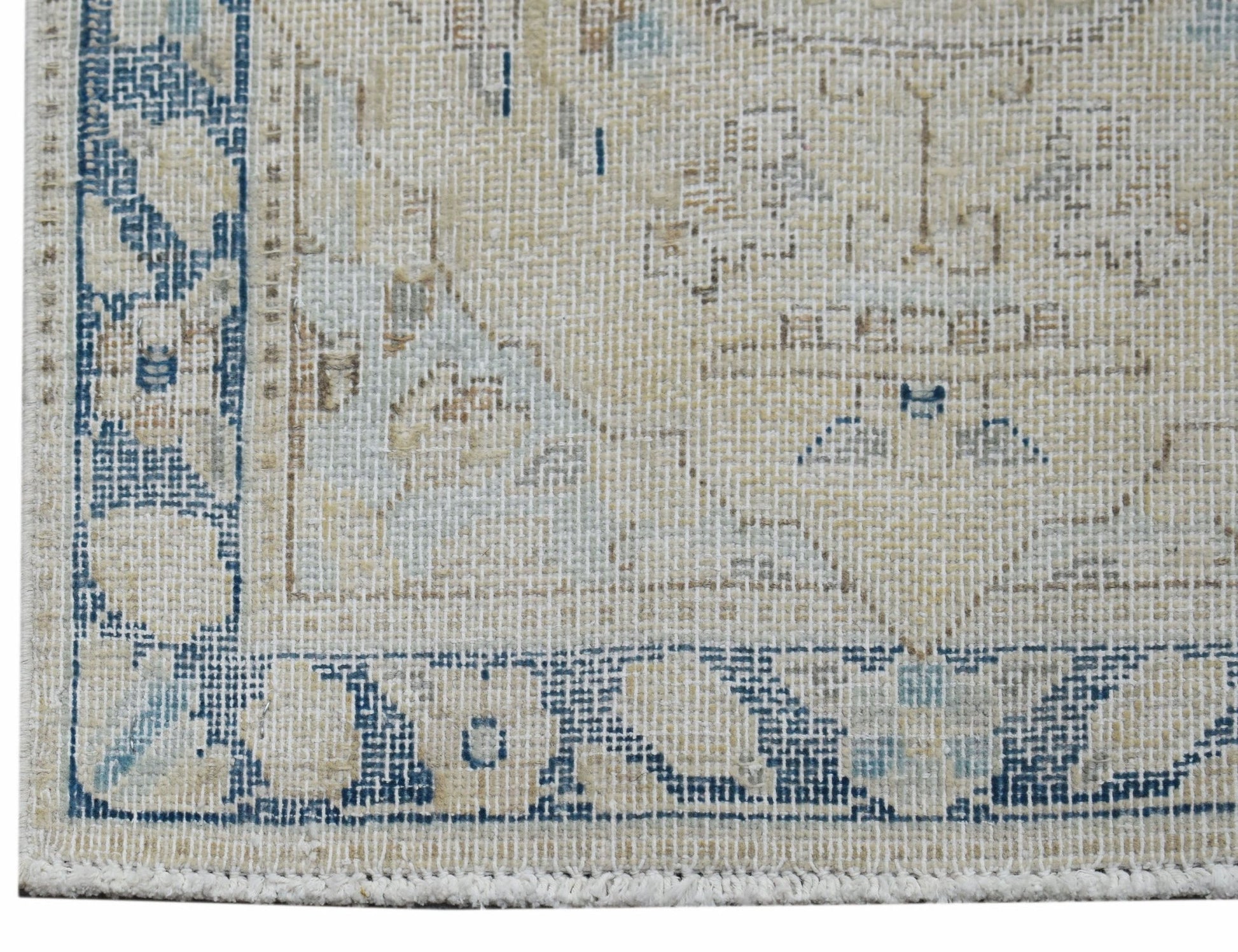 A close-up of a vintage Persian Kerman rug featuring a blue and beige floral medallion pattern.