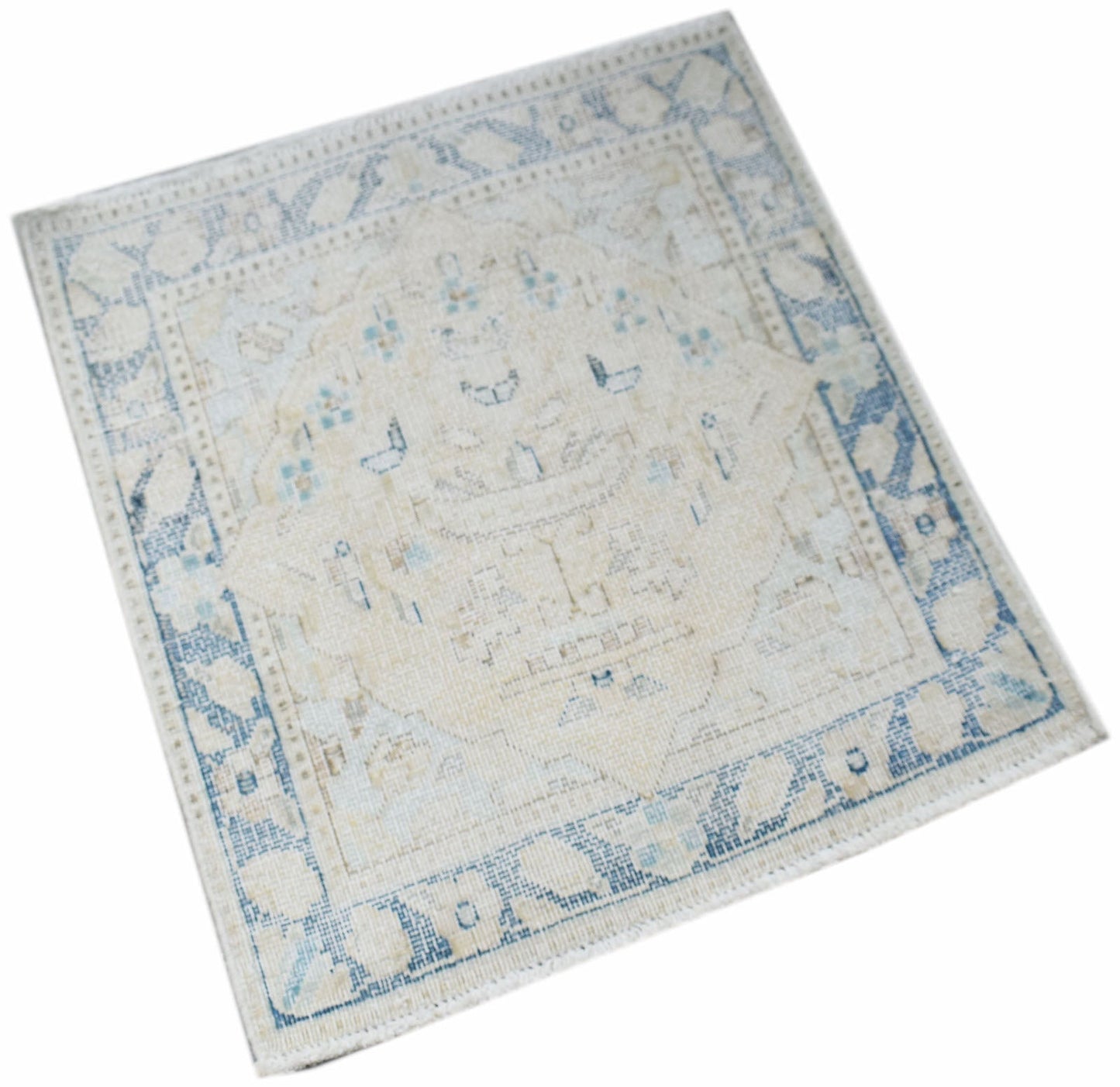 A mini vintage Persian Kerman rug featuring a central medallion in soft blue and cream tones.