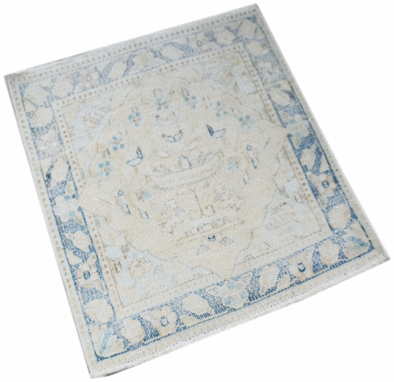 A mini vintage Persian Kerman rug featuring a central medallion in soft blue and cream tones.