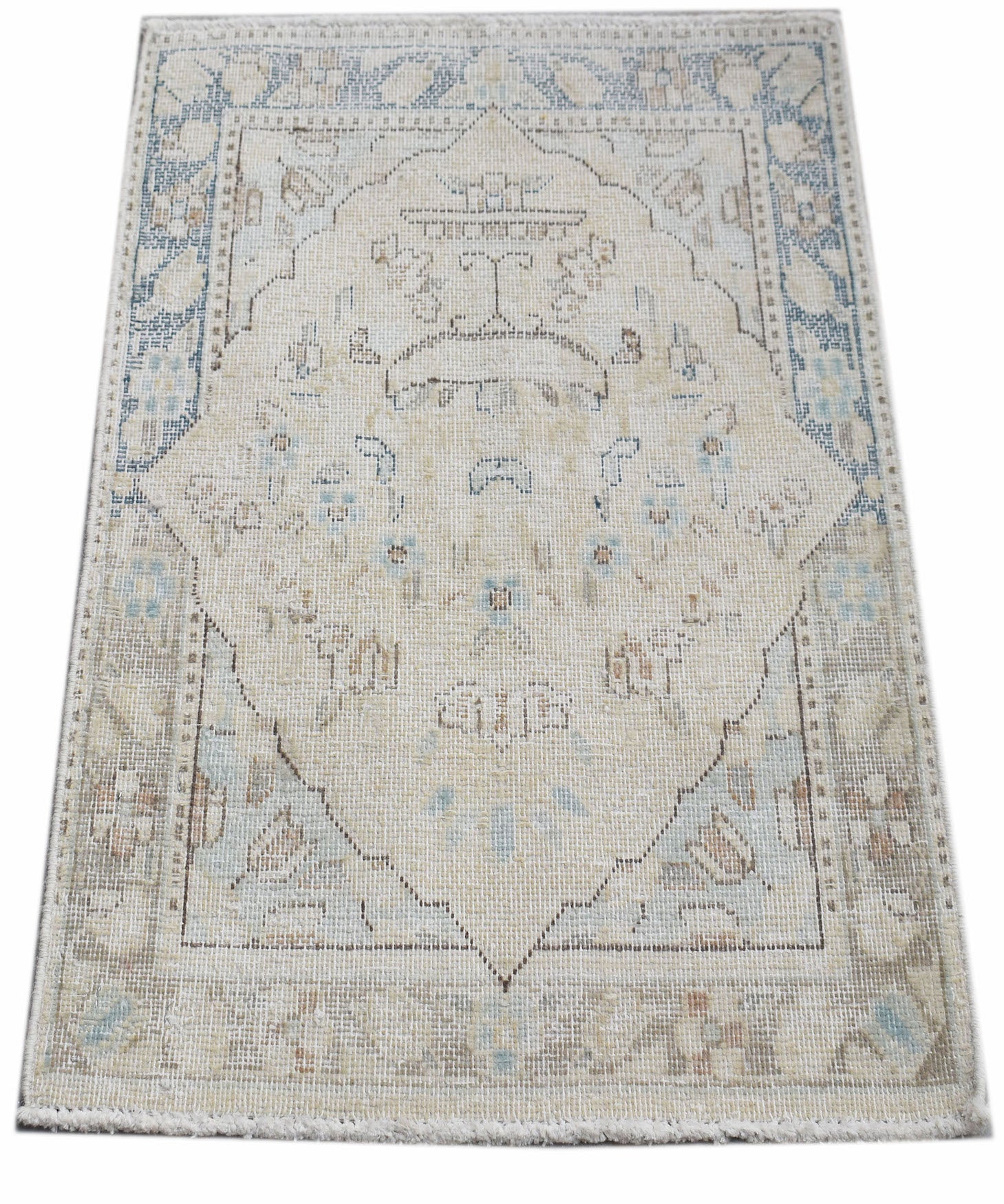 A mini vintage Persian Kerman rug featuring a central medallion in soft blue and beige tones.
