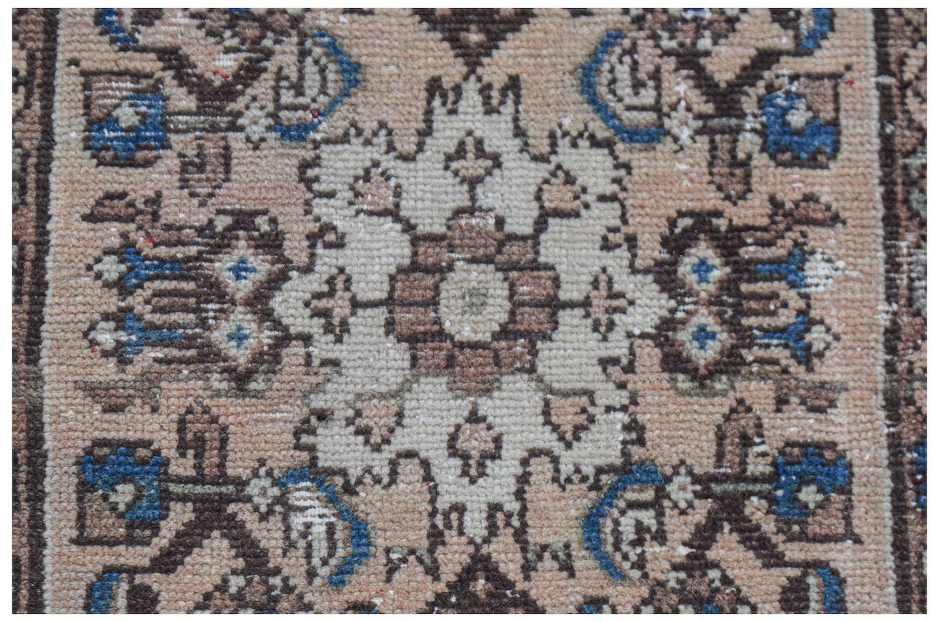 Mini vintage Persian rug with a central floral medallion and blue accents.
