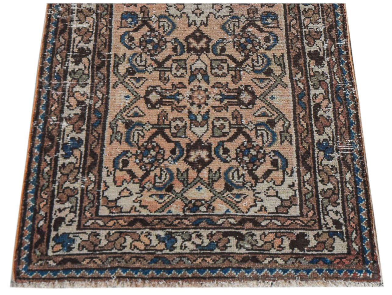A handwoven vintage Persian rug featuring a geometric floral pattern in muted earth tones.