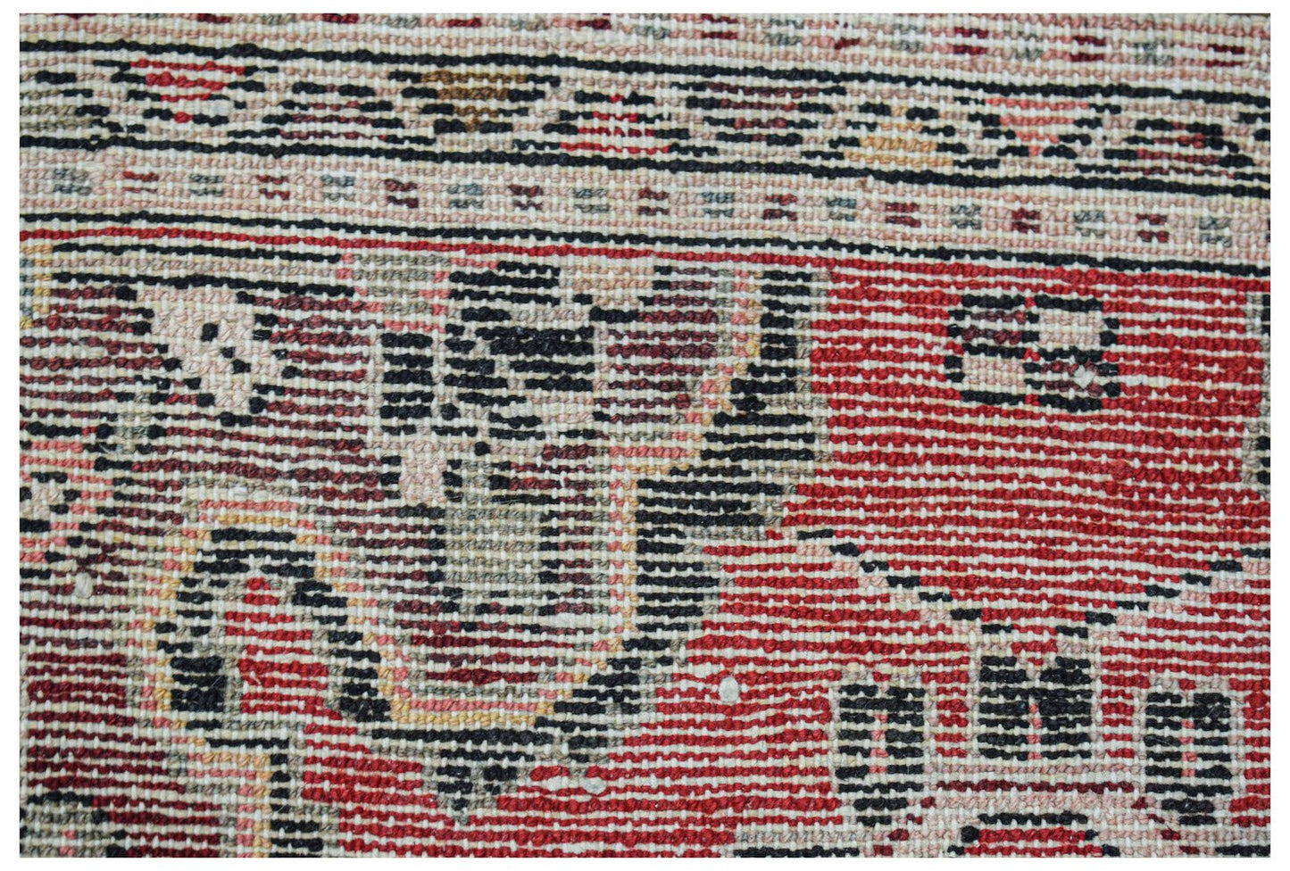 A close-up of a handwoven vintage Persian Sarouk rug featuring intricate red and black patterns.
