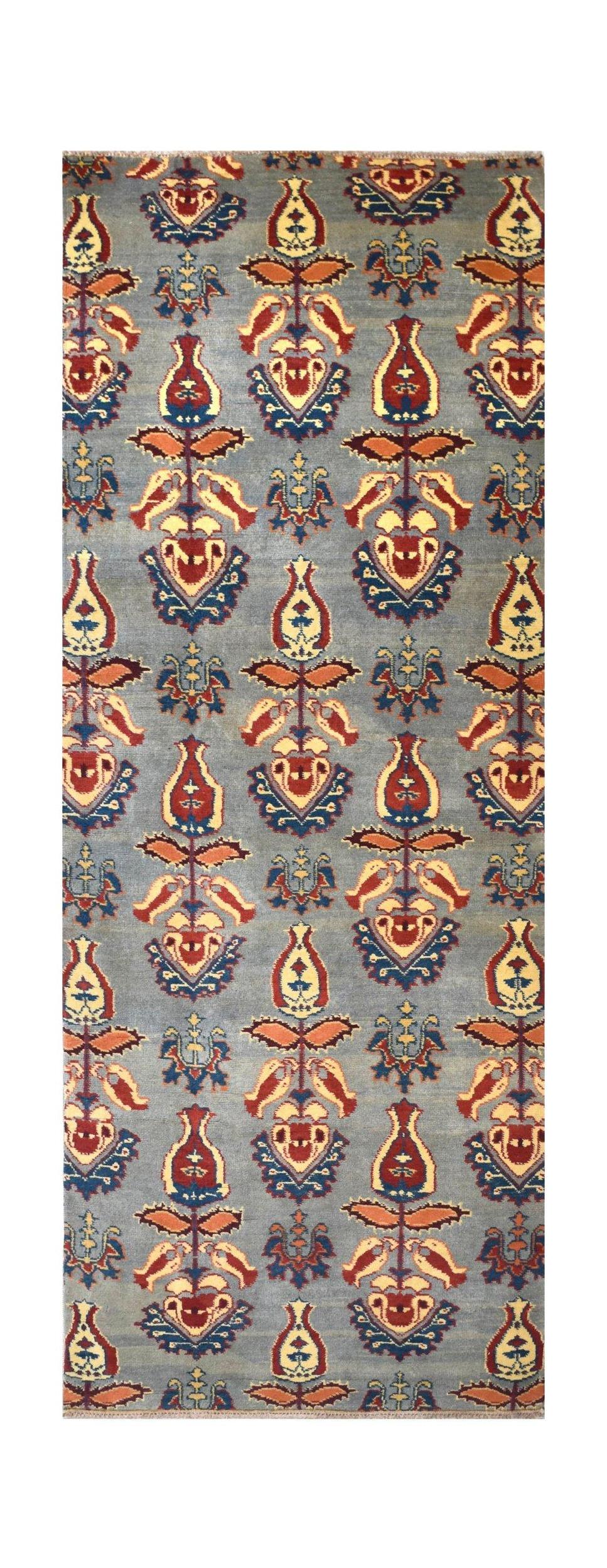 An Afghan Chobi runner rug featuring a repeating floral motif in red, yellow, and blue on grey.
