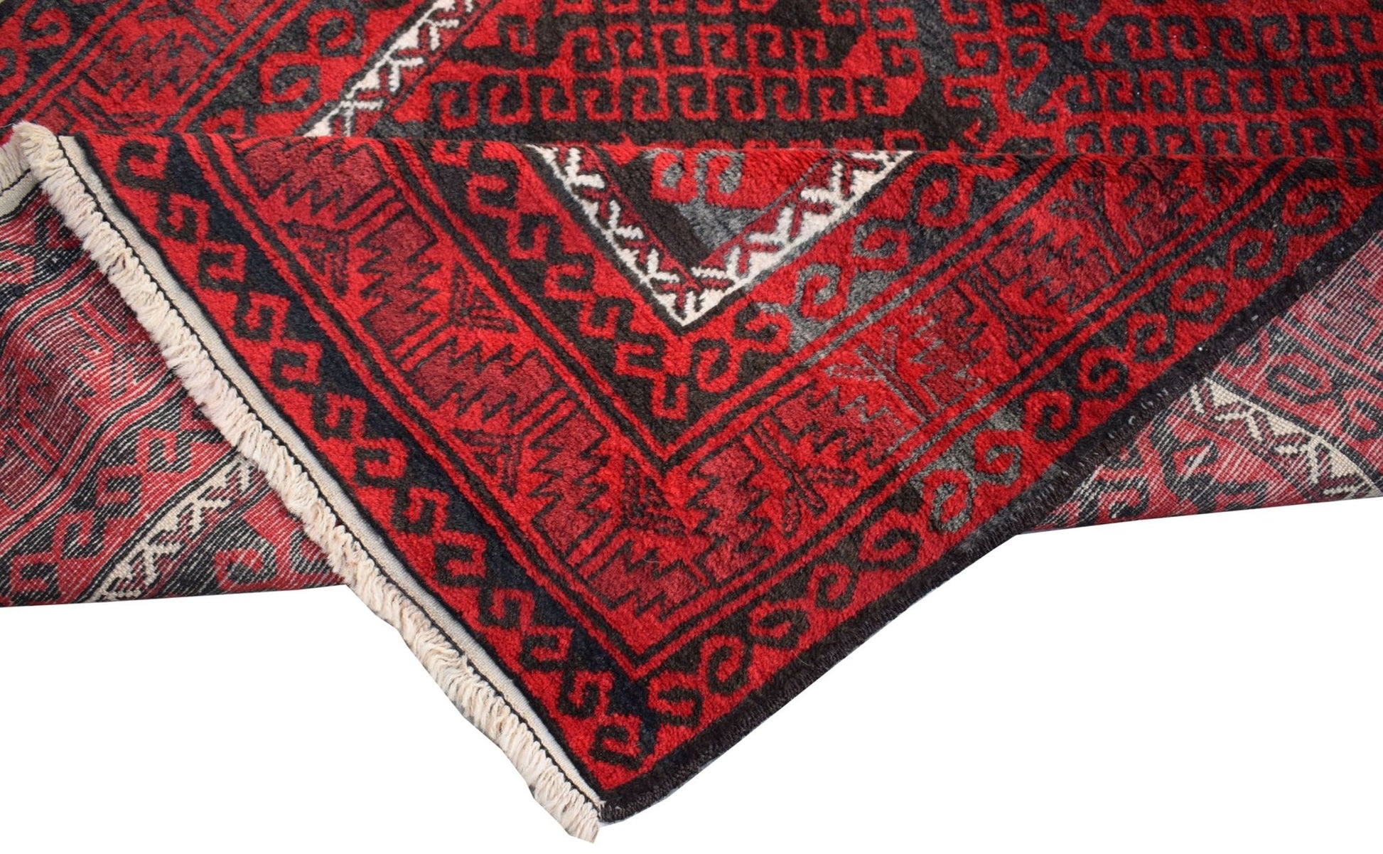 A vintage handmade Afghan Baluch wool rug featuring traditional geometric patterns in red and black.