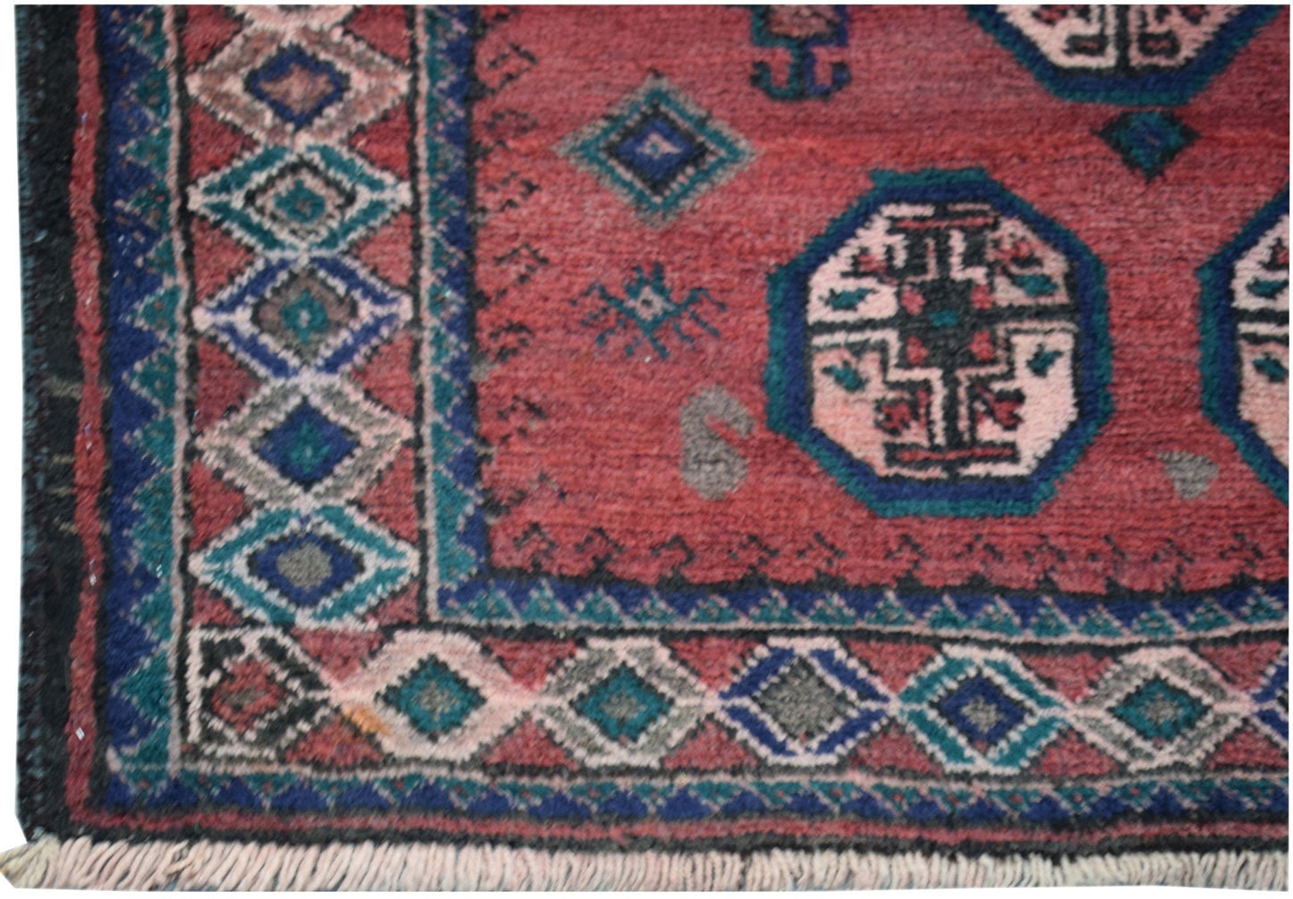 A vintage handmade Afghan Baluch rug featuring a red field with geometric motifs and diamond borders.