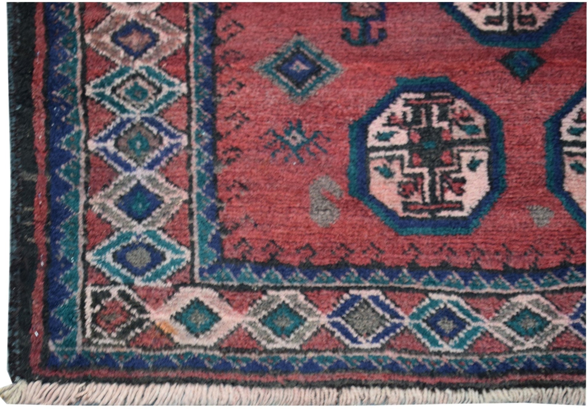 A vintage handmade Afghan Baluch rug featuring a red field with geometric motifs and diamond borders.