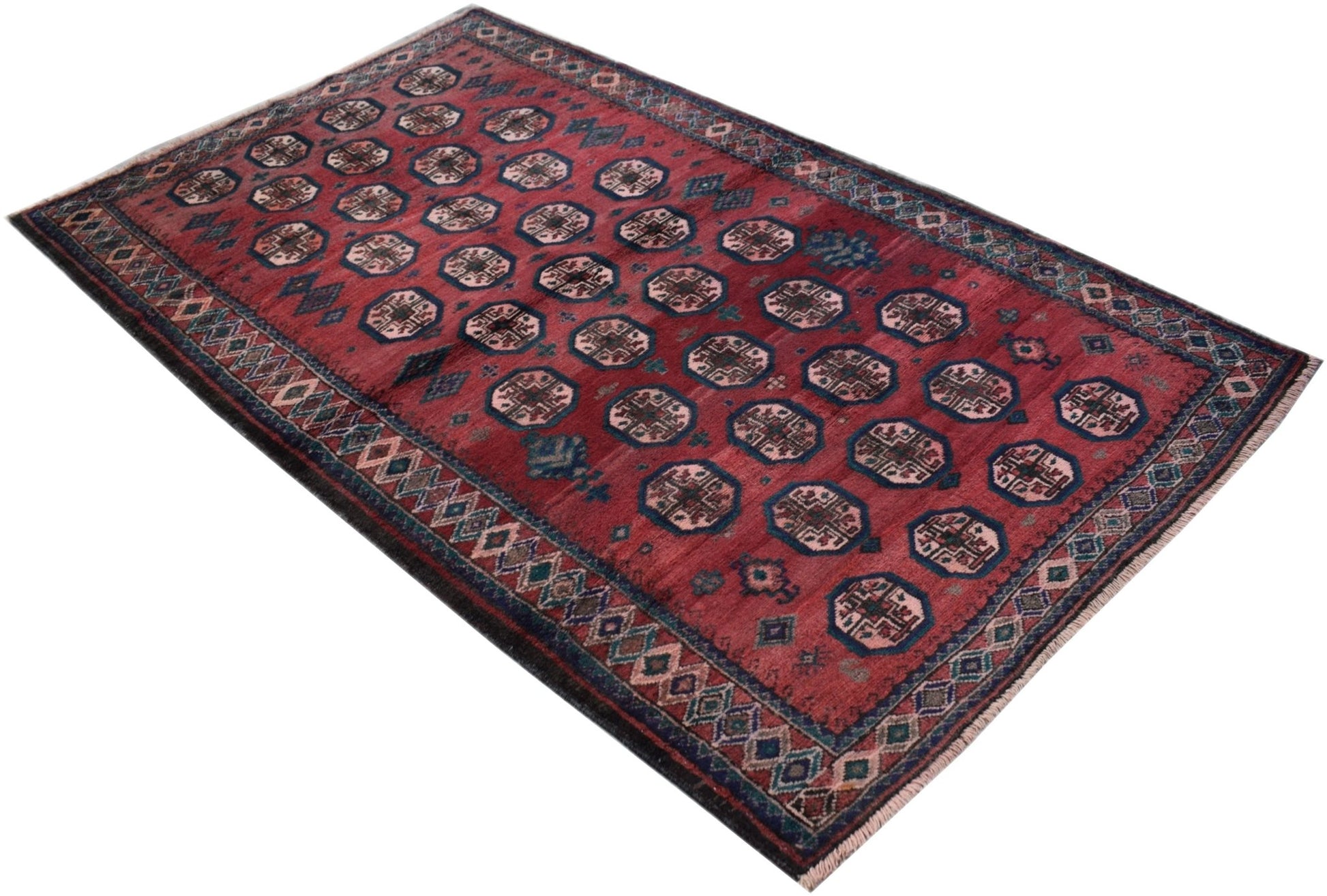 A vintage Afghan Baluch rug featuring a repeating geometric pattern in deep red and blue tones.