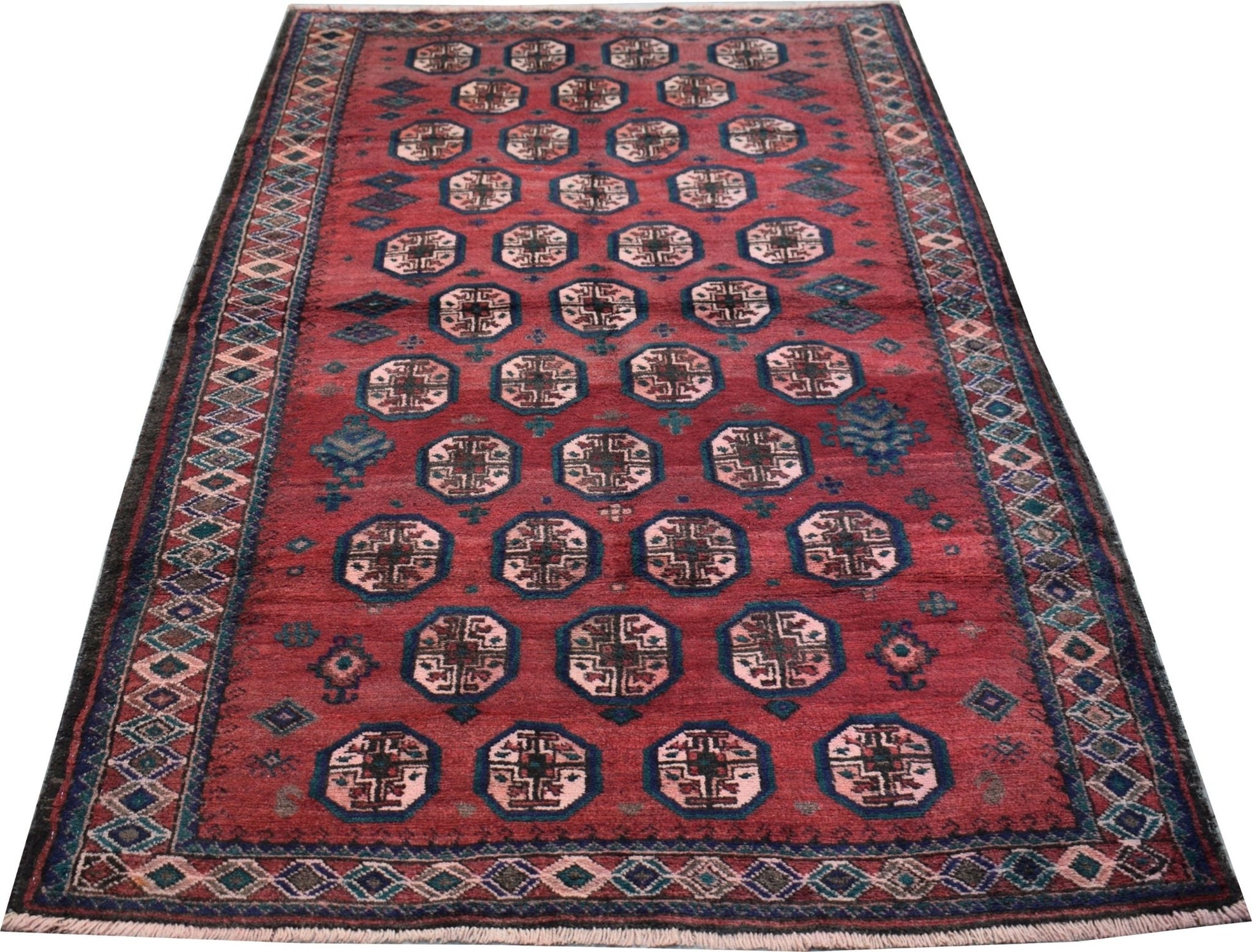 A vintage Afghan Baluch rug featuring a repeating octagonal pattern on a deep red field.