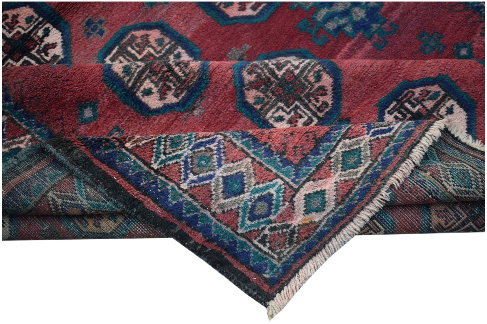 A vintage handmade Afghan Baluch rug featuring geometric patterns in red, blue, and cream tones.