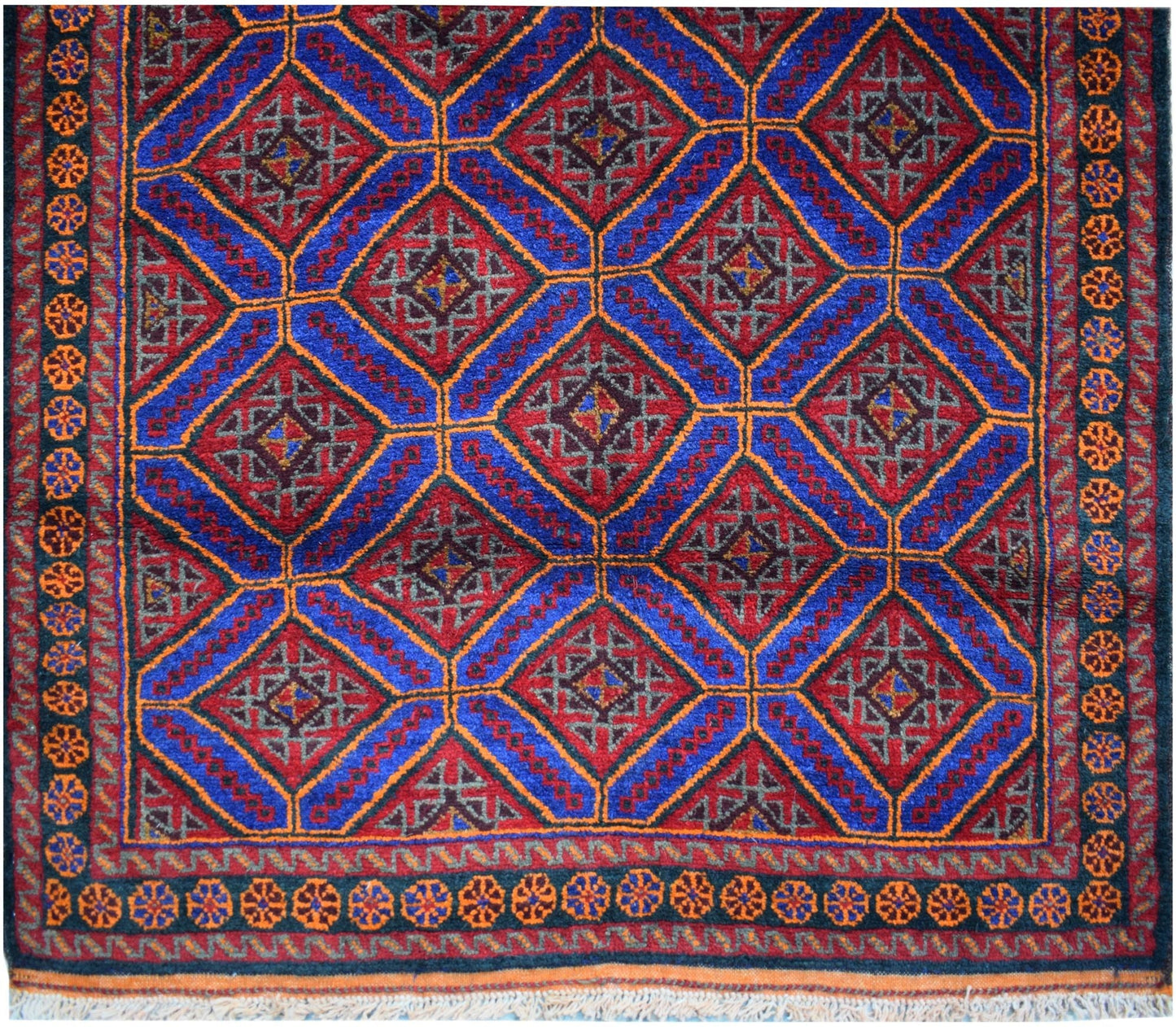 A vintage Afghan Baluch wool rug featuring a repeating diamond pattern in red and blue.