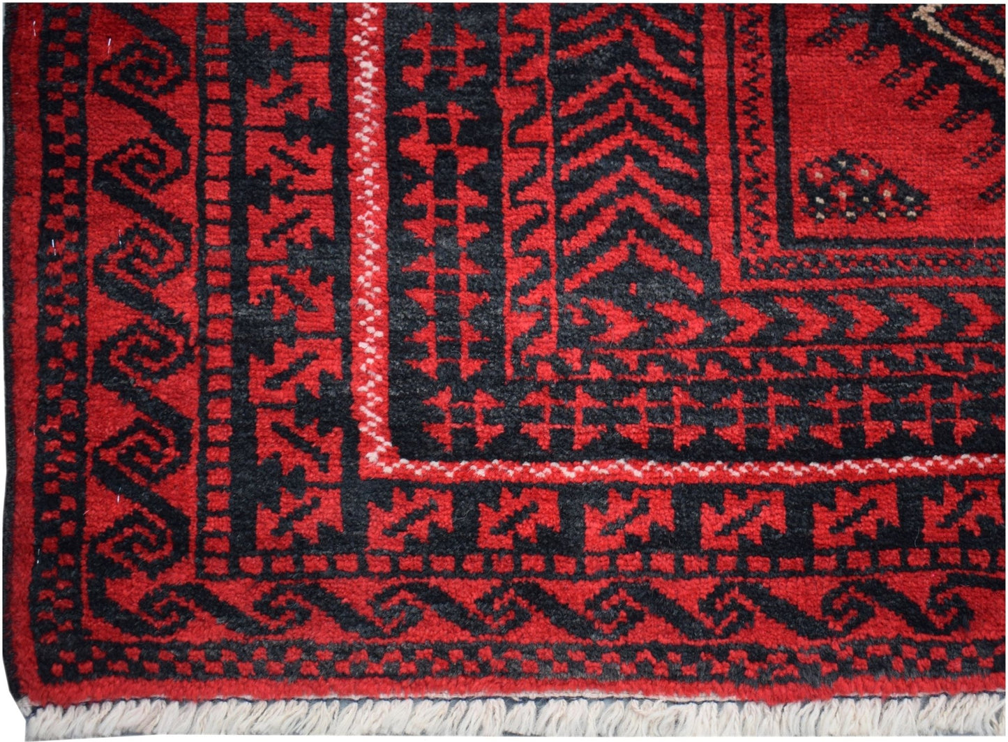 A vintage Afghan Baluch rug featuring traditional geometric patterns in red and black wool.