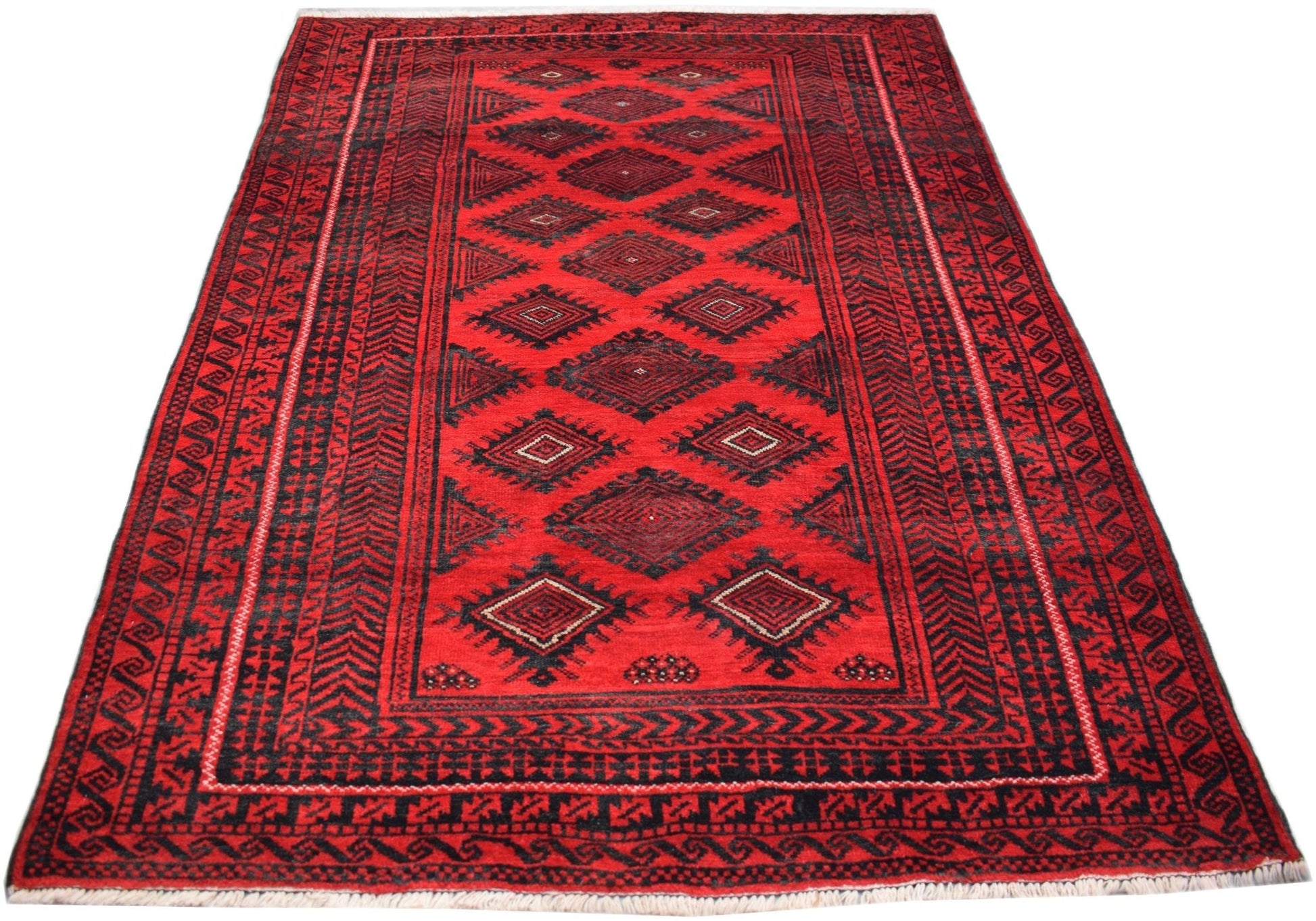 A vintage handmade Afghan Baluch rug featuring a repeating diamond pattern in red and black.