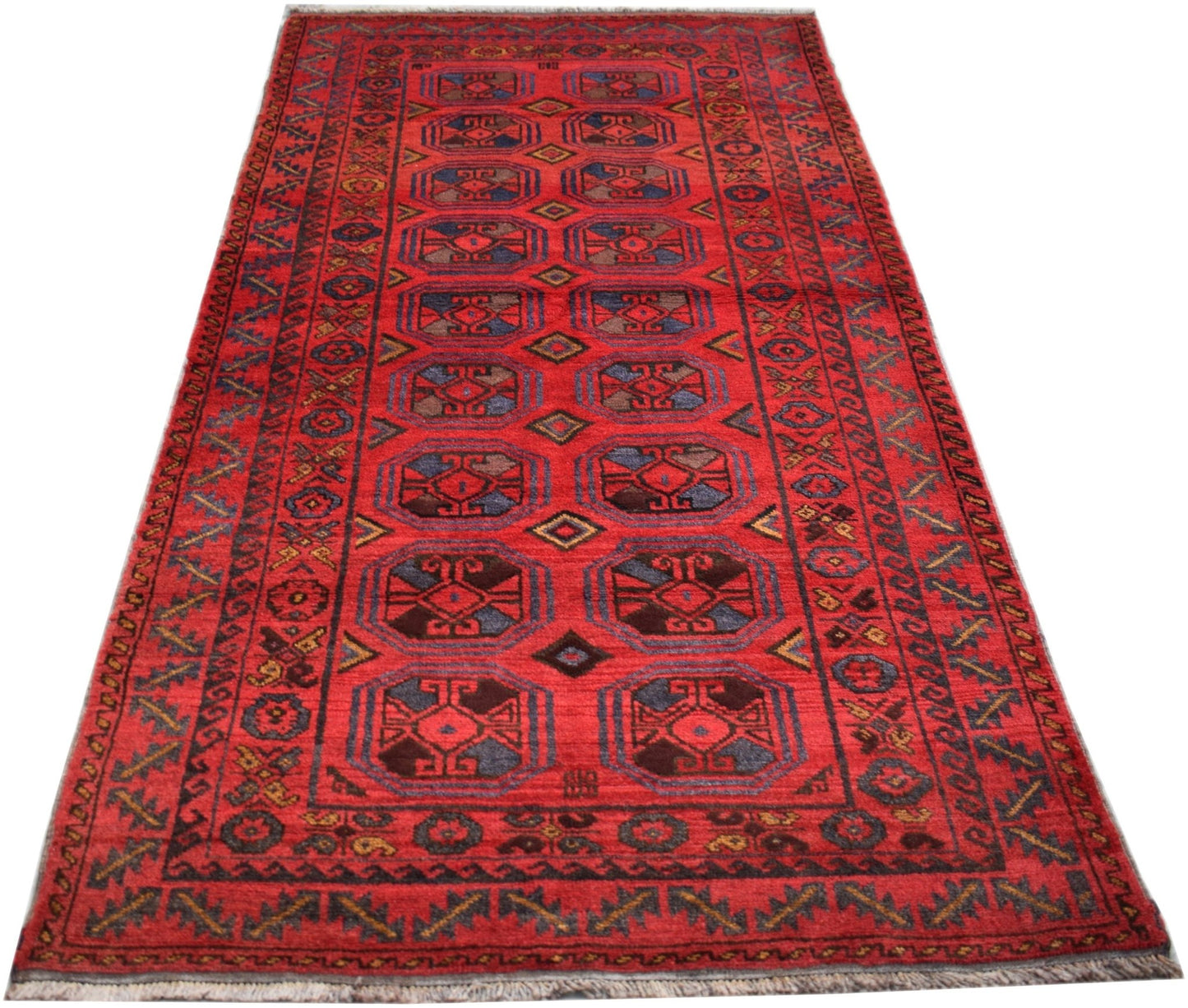 A vintage Afghan Baluch rug featuring a repeating geometric pattern in deep red and dark tones.
