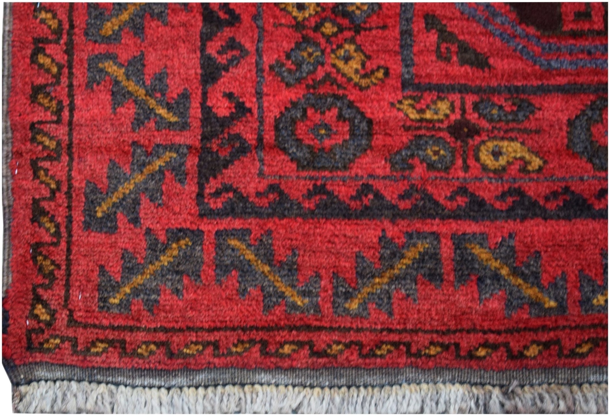 A vintage Afghan Baluch wool rug featuring traditional geometric patterns in red and dark tones.