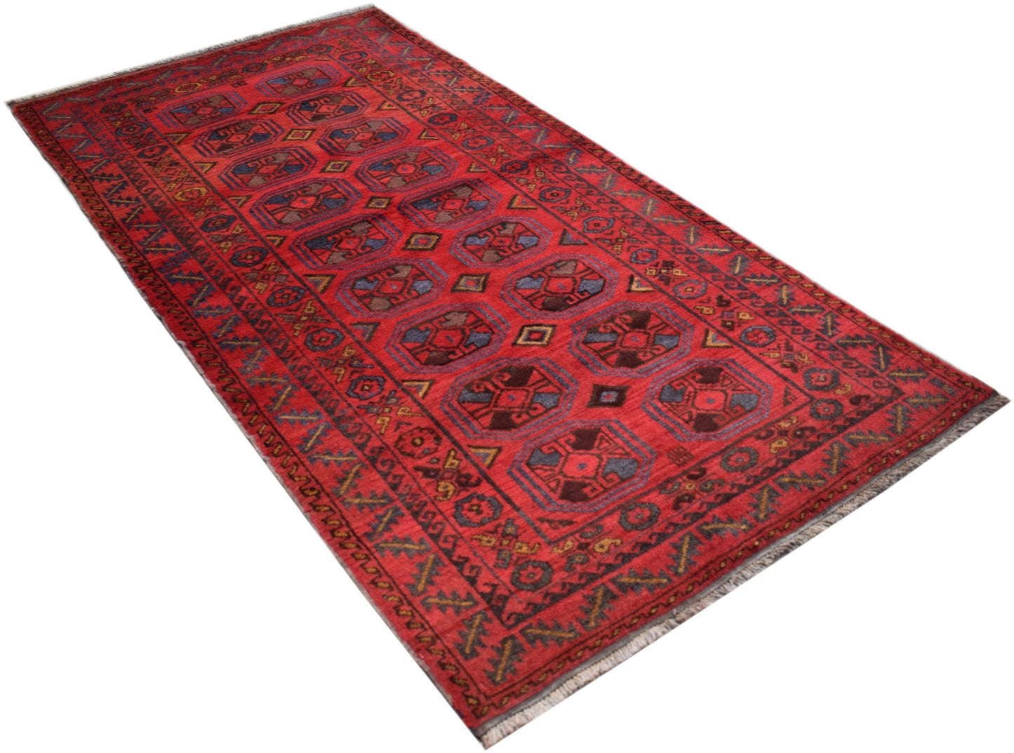 A vintage Afghan Baluch rug featuring a repeating geometric pattern in deep red and blue tones.