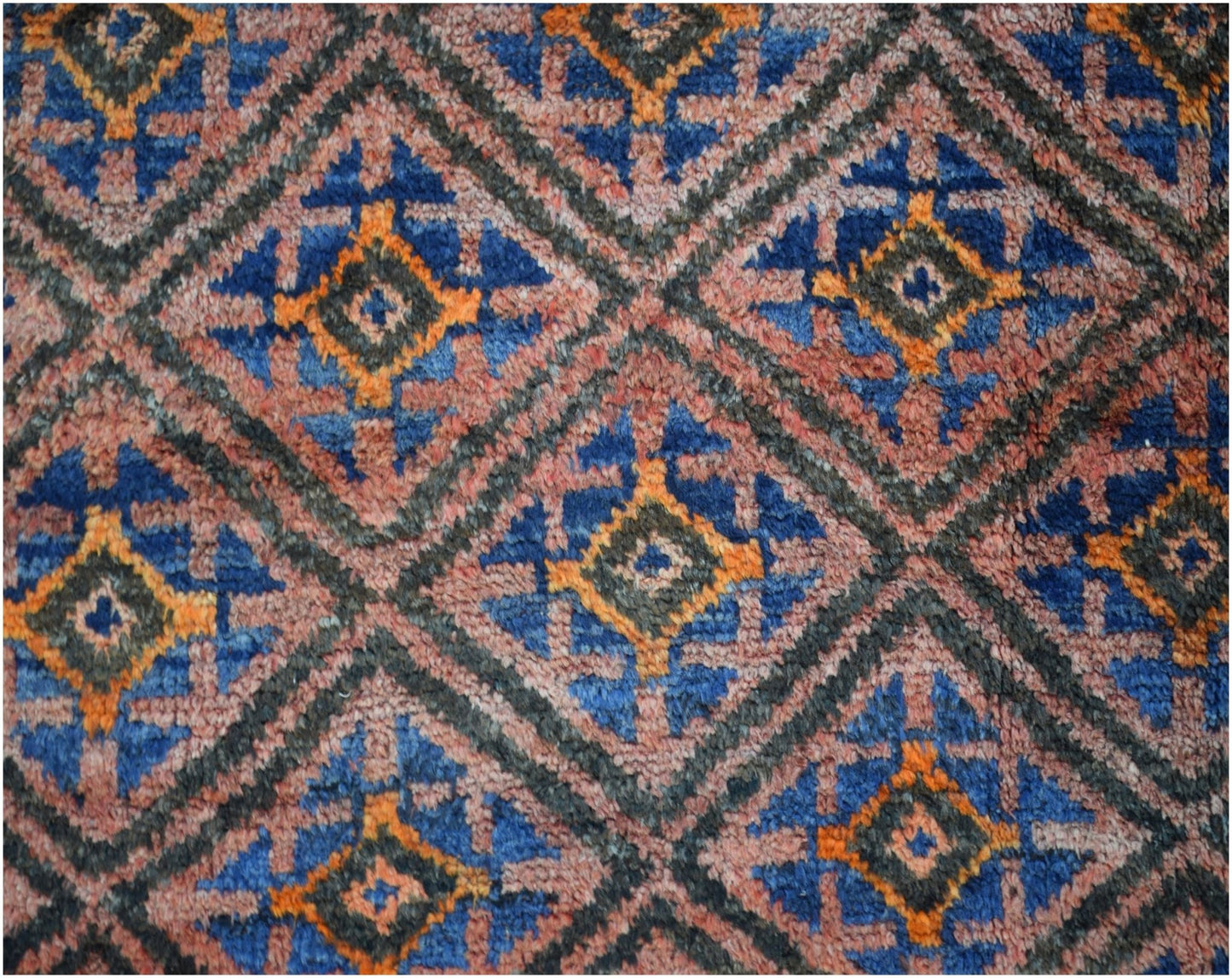 A vintage Afghan Baluch wool rug featuring a repeating diamond pattern in blue, orange, and pink.