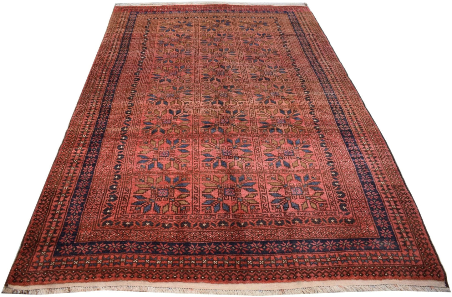 A vintage Afghan Baluch rug featuring a repeating geometric floral pattern in red and blue tones.