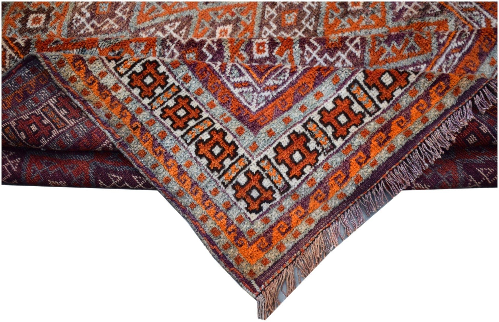 A vintage Afghan Baluch rug featuring intricate geometric patterns in orange, purple, and grey.