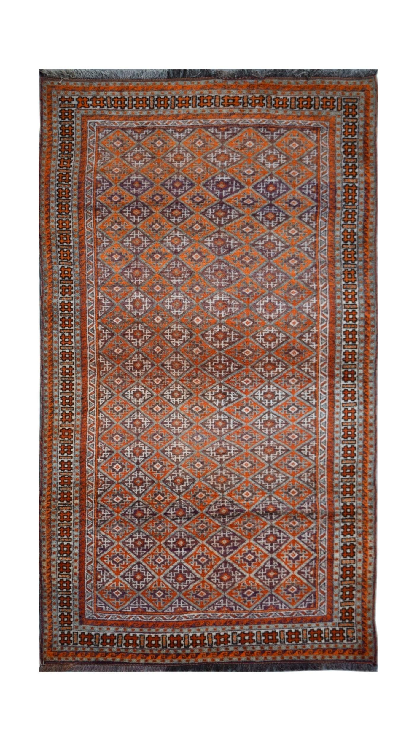 A vintage handmade Afghan Baluch rug featuring a repeating diamond pattern in orange and grey.