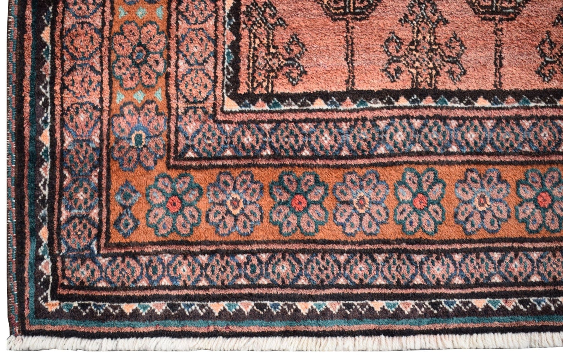 A vintage Afghan Baluch rug featuring a geometric floral border in rust, blue, and black wool.