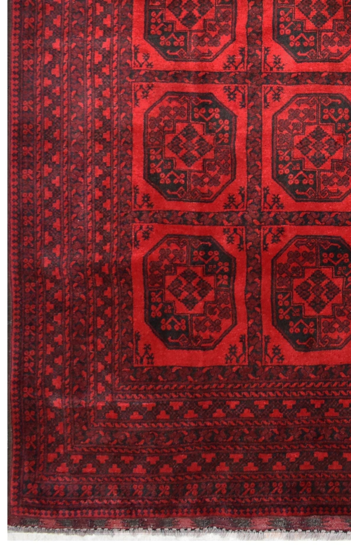 A vintage handmade Afghan Turkmen rug featuring a geometric octagonal pattern in red and black.
