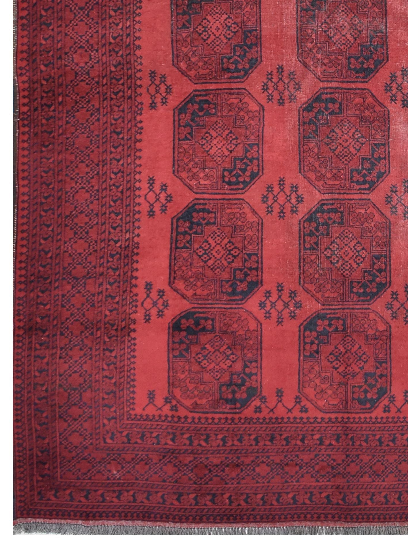 A vintage handmade Afghan Turkmen rug featuring a deep red field with repeating dark octagons.