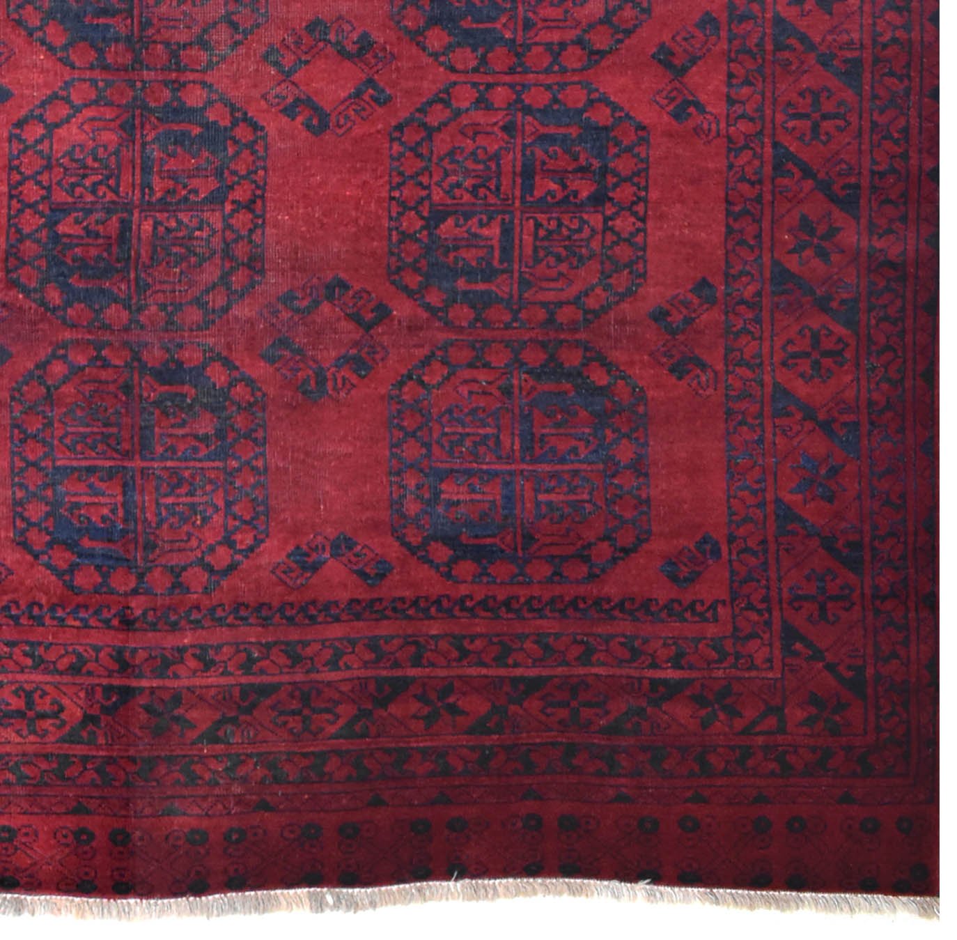 A vintage handmade Afghan Turkmen rug featuring dark blue geometric guls on a deep red background.