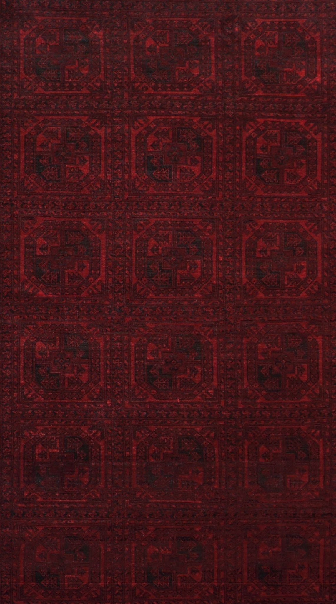 A vintage handmade Afghan Turkmen rug featuring a repeating geometric pattern in deep red tones.