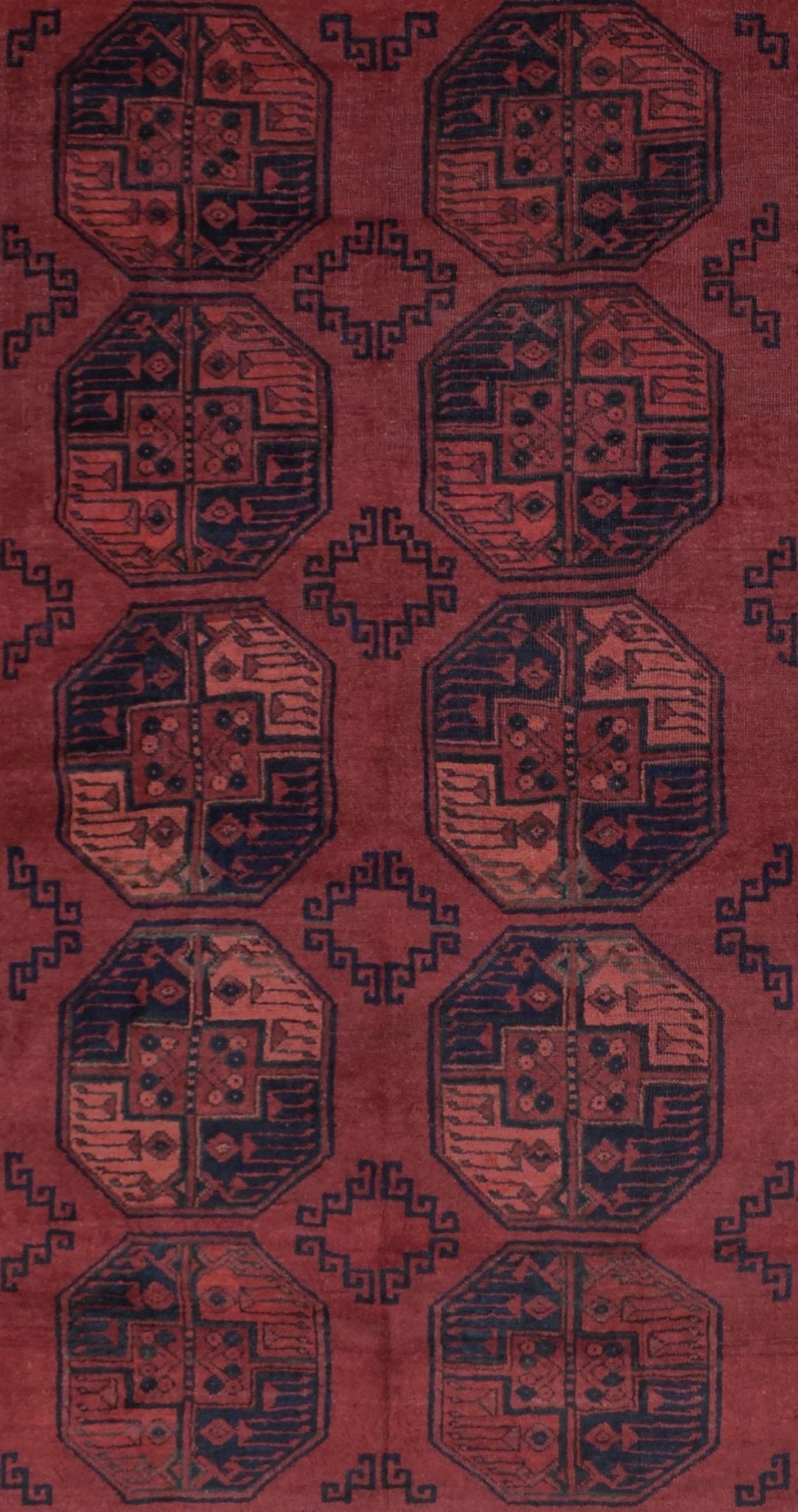 A vintage handmade Afghan Turkmen rug featuring a repeating geometric octagonal pattern in red.