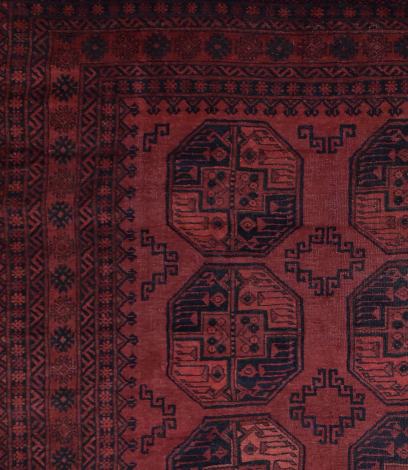 A vintage Afghan Turkmen rug featuring dark red wool with geometric octagonal motifs.