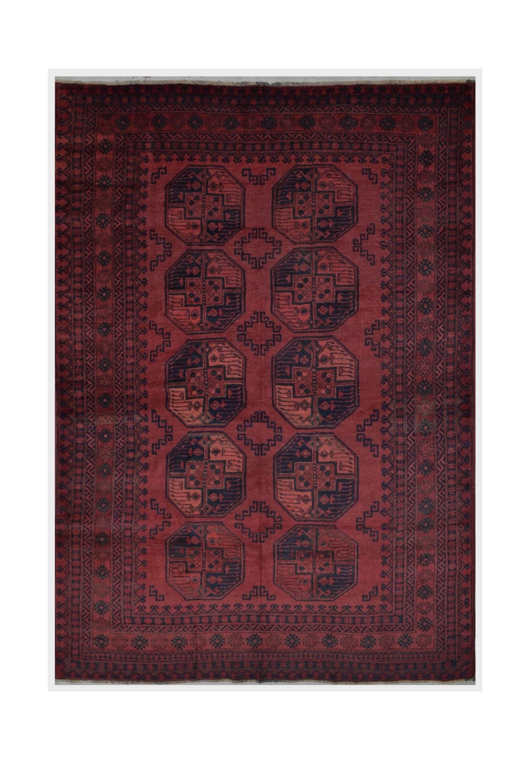 A vintage handmade Afghan Turkmen rug featuring a deep red field with repeating geometric octagons.