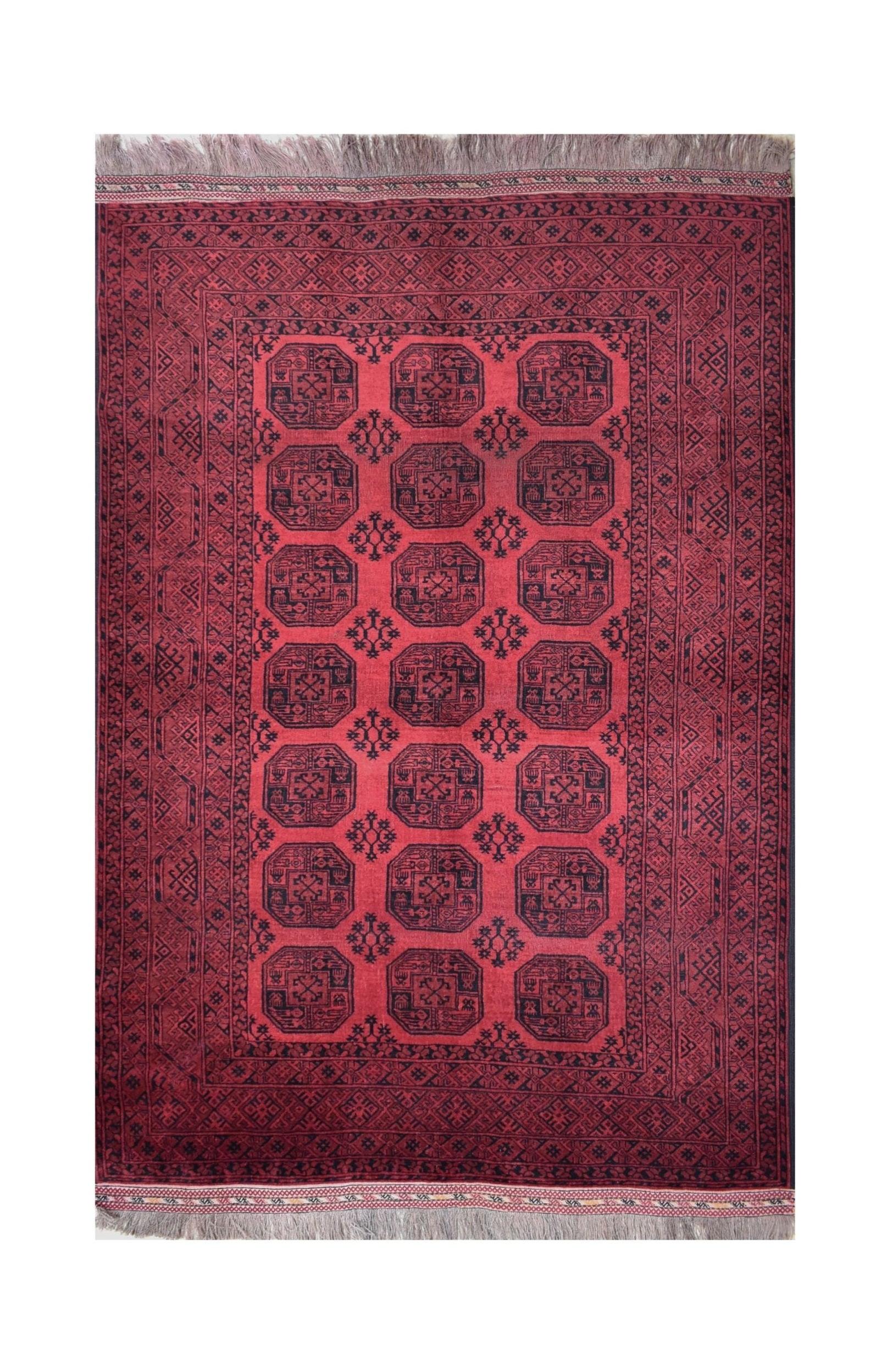A vintage handmade Afghan Turkmen rug featuring a repeating octagonal gul pattern in red and black.