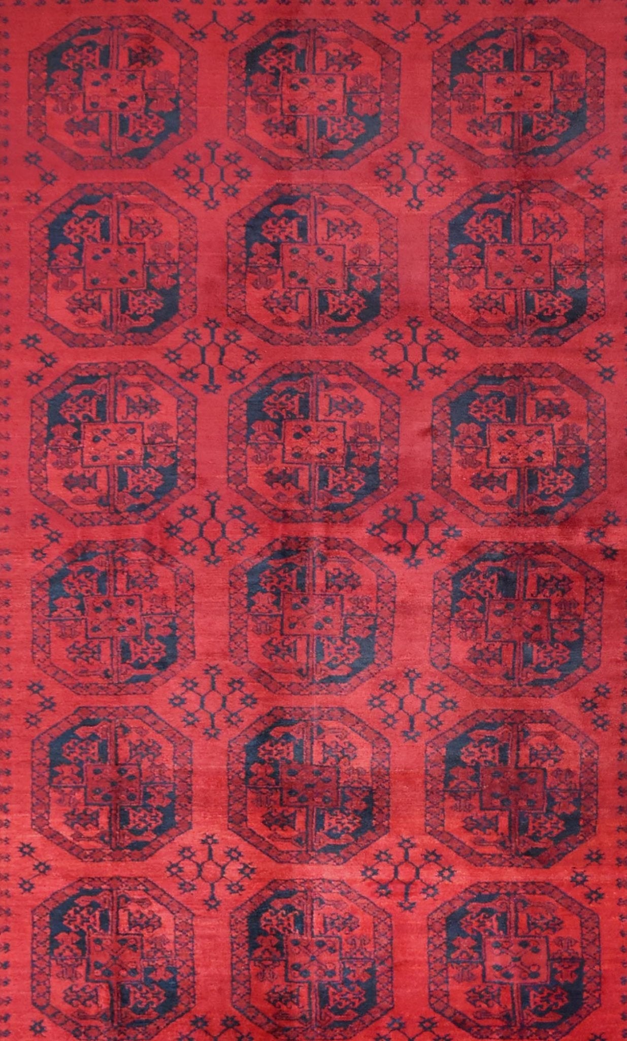 A vintage handmade Afghan Turkmen rug featuring a repeating geometric octagonal pattern in red.