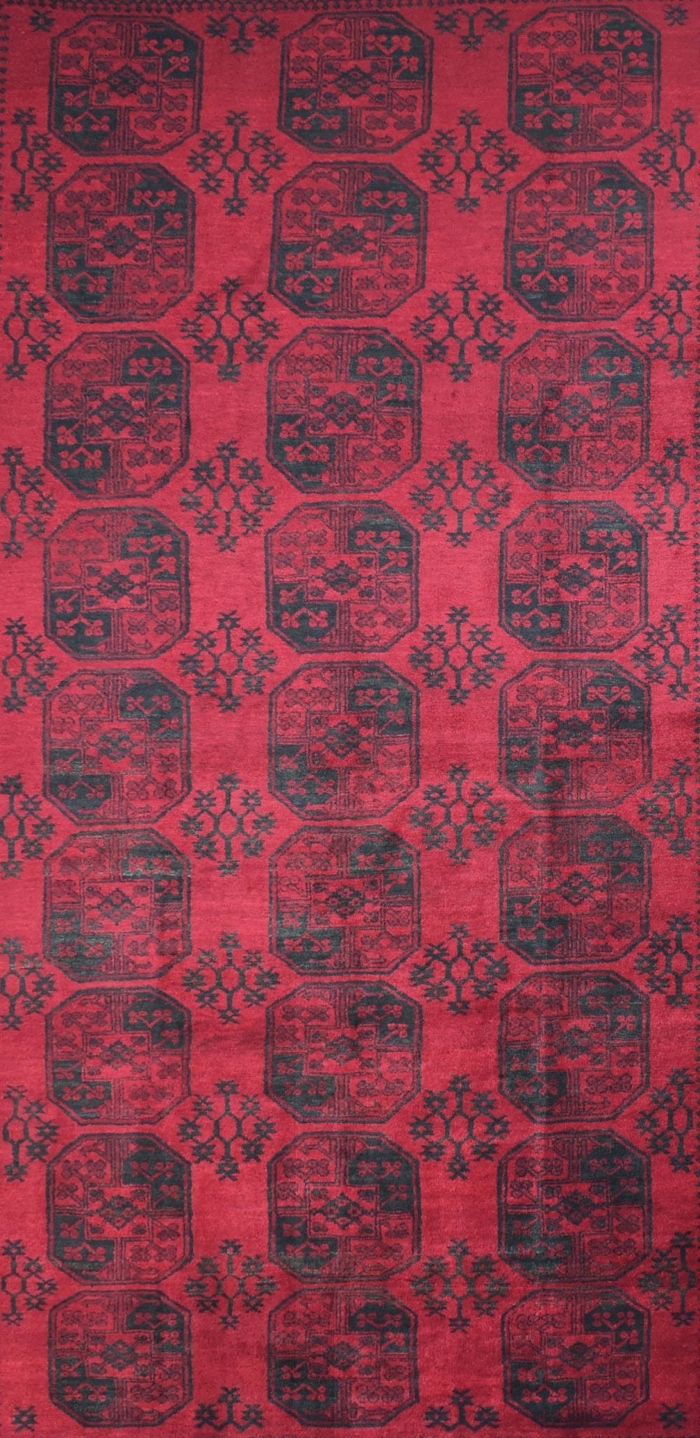 A vintage handmade Afghan Turkmen rug featuring a repeating geometric pattern in red and dark blue.