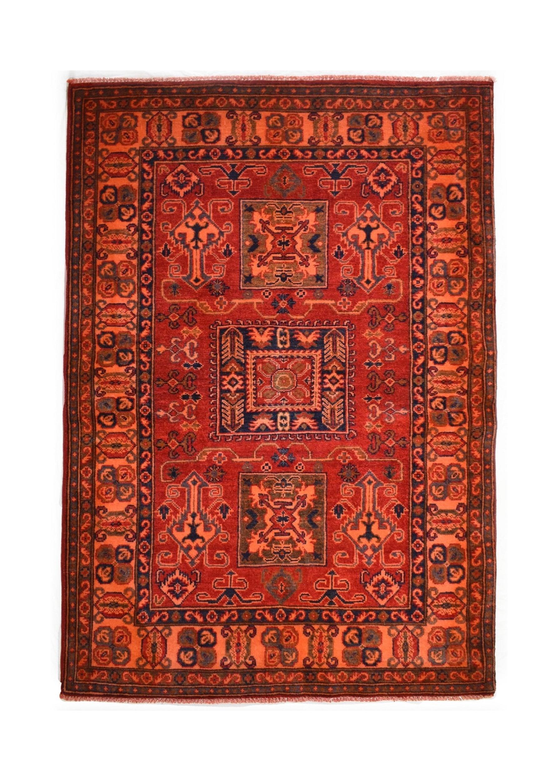 Handmade Afghan Kazakh rug featuring a geometric pattern in shades of red, orange, and blue.