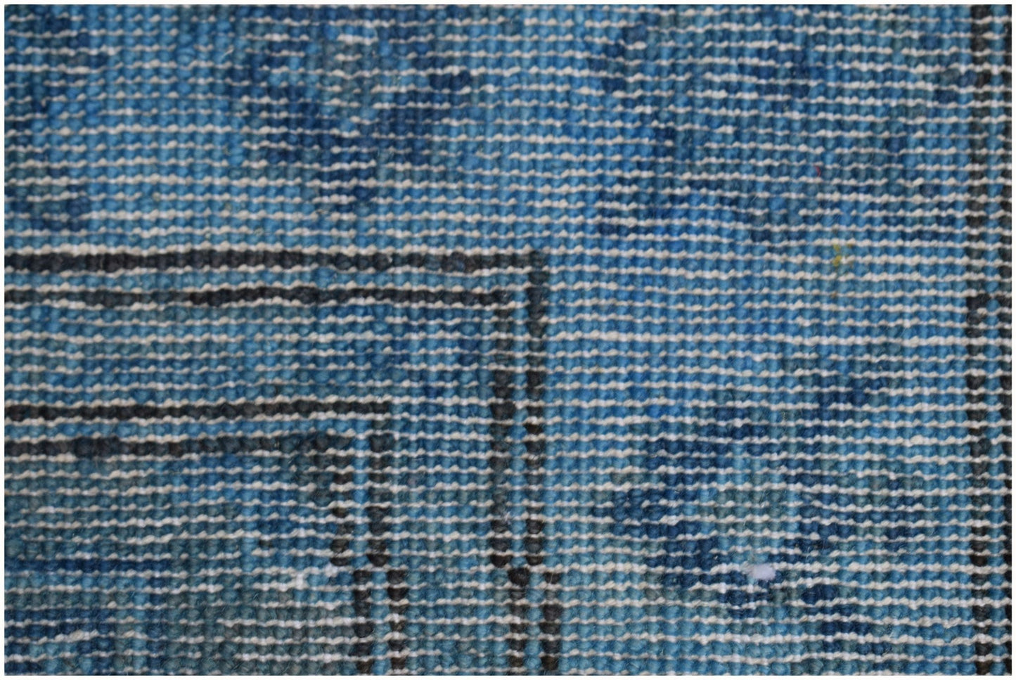 A close-up view of a handmade Afghan Chobi runner featuring a textured blue overdyed wool pattern.