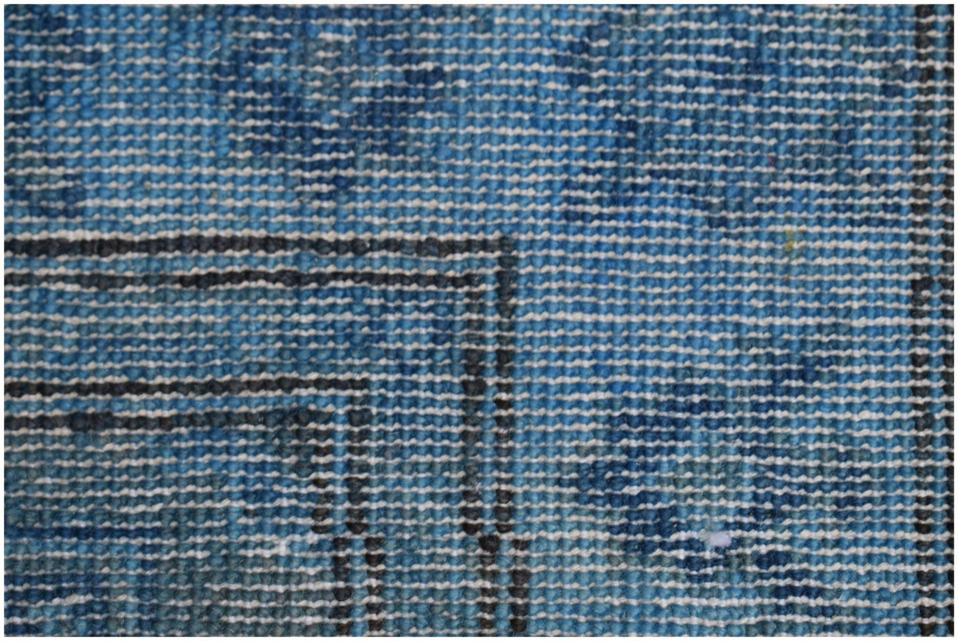 A close-up view of a handmade Afghan Chobi runner featuring a textured blue overdyed wool pattern.