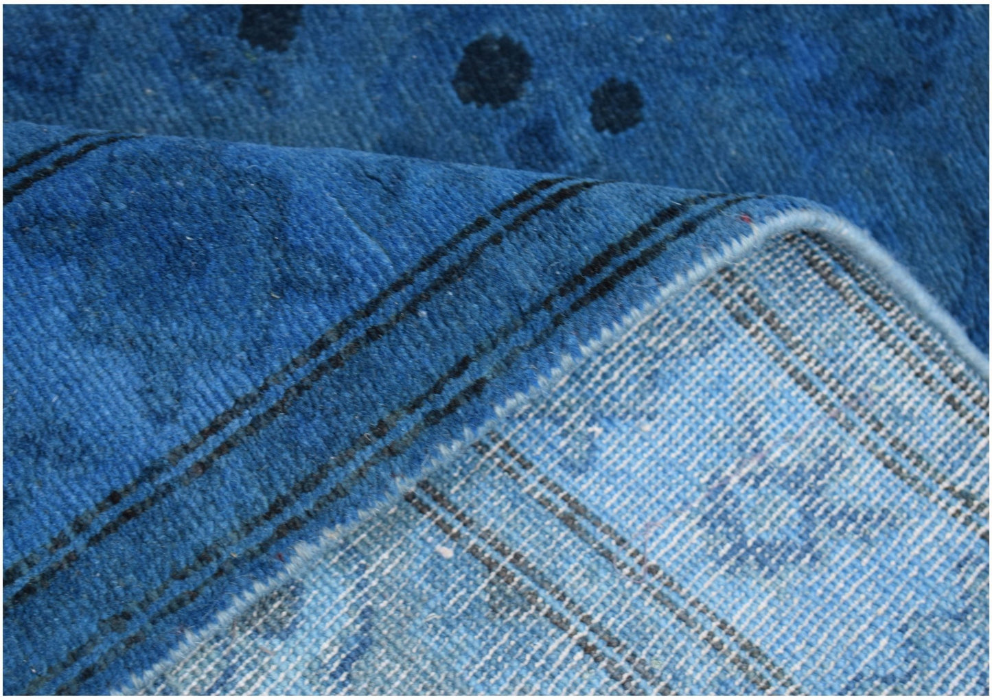 A close-up view of a blue overdyed Afghan Chobi runner showing its wool texture and backing.
