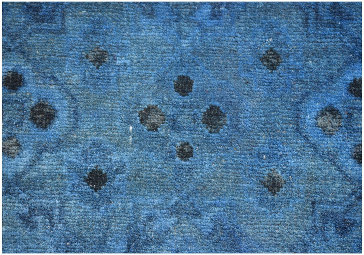 A blue overdyed Afghan Chobi runner featuring a repeating geometric pattern of dark floral motifs.